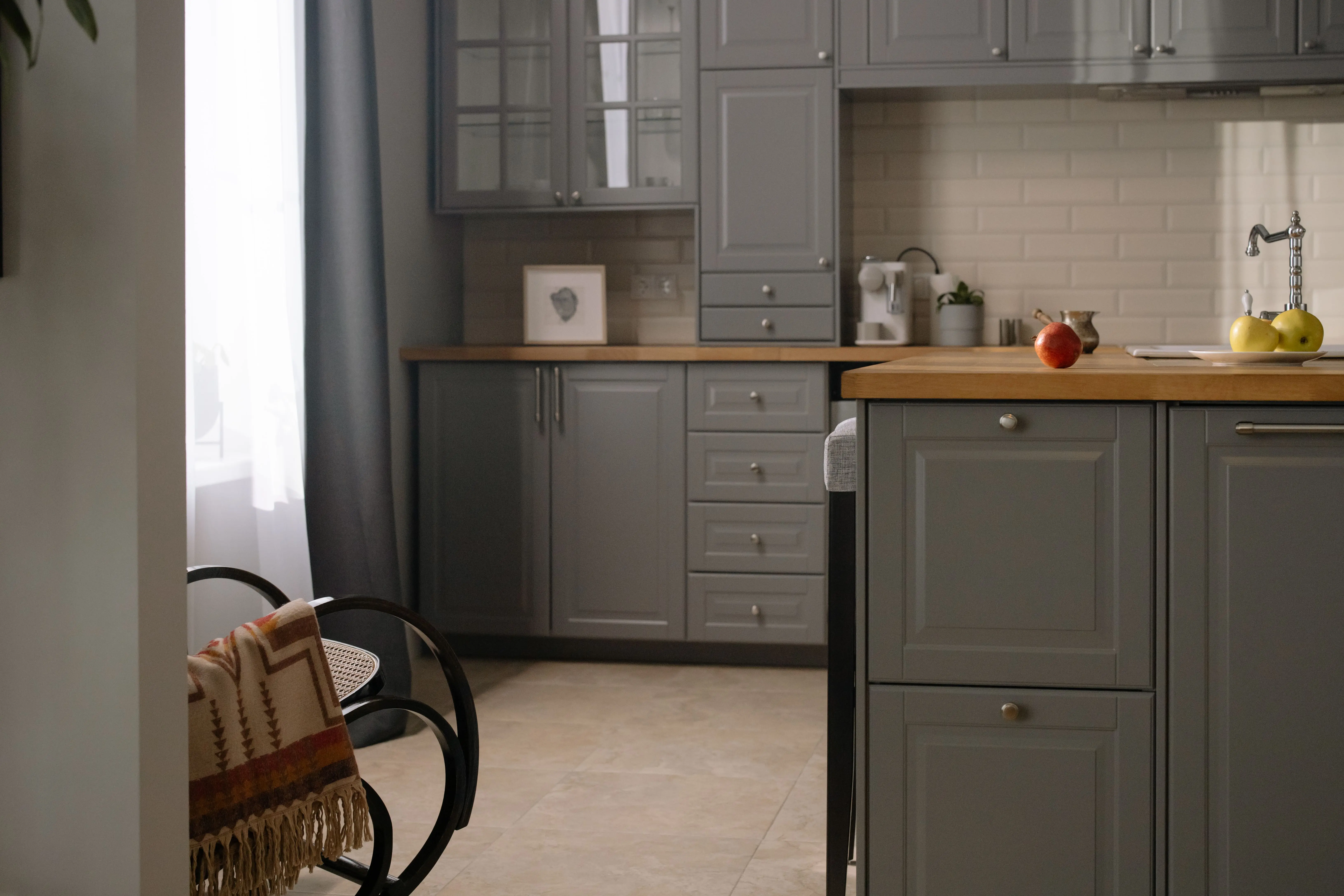 gray tile Stylish gray kitchen interior with wooden countertops, natural lighting, and modern design elements.