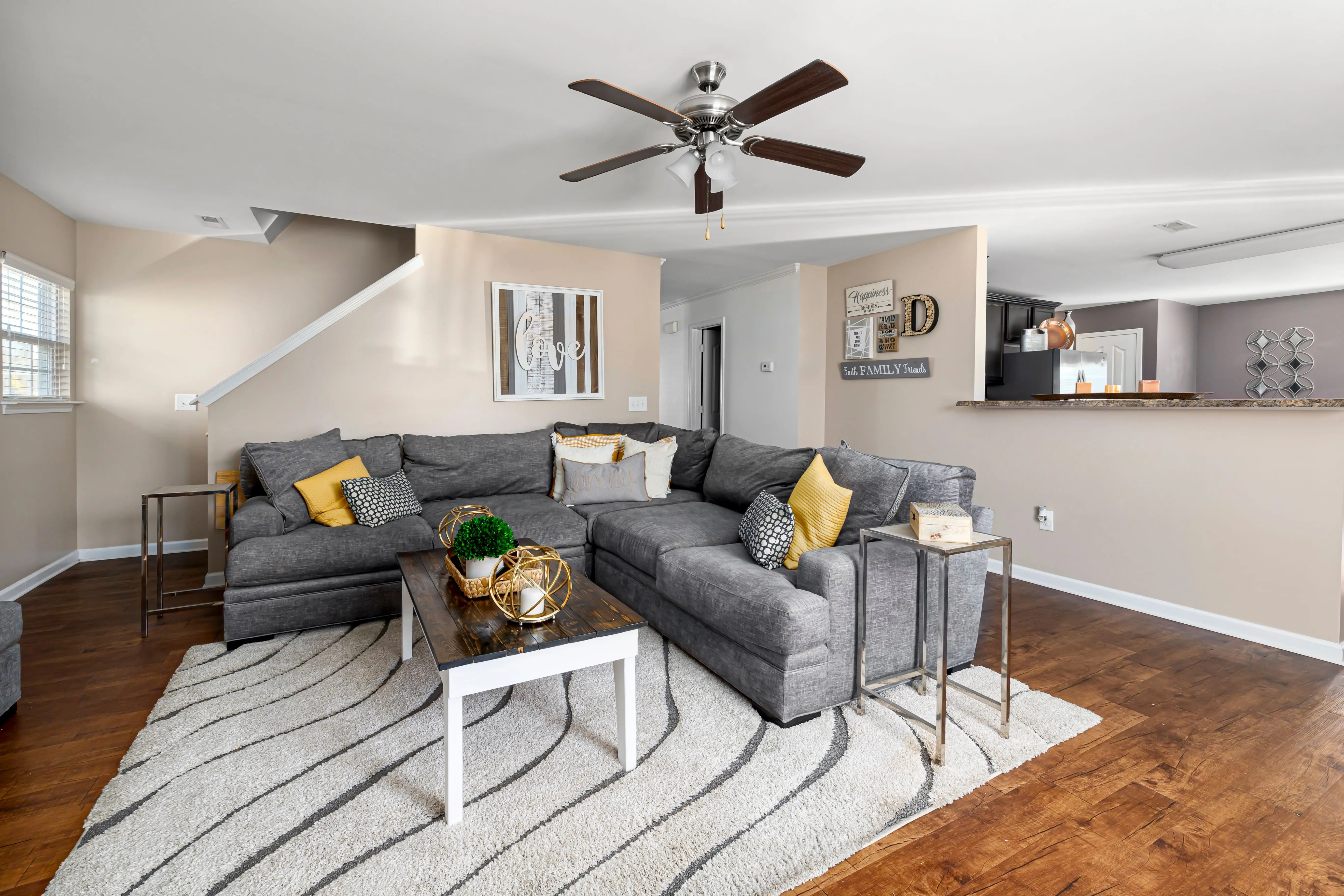 gray sectional Stylish living room featuring a gray sectional sofa, wooden flooring, and decor accents.