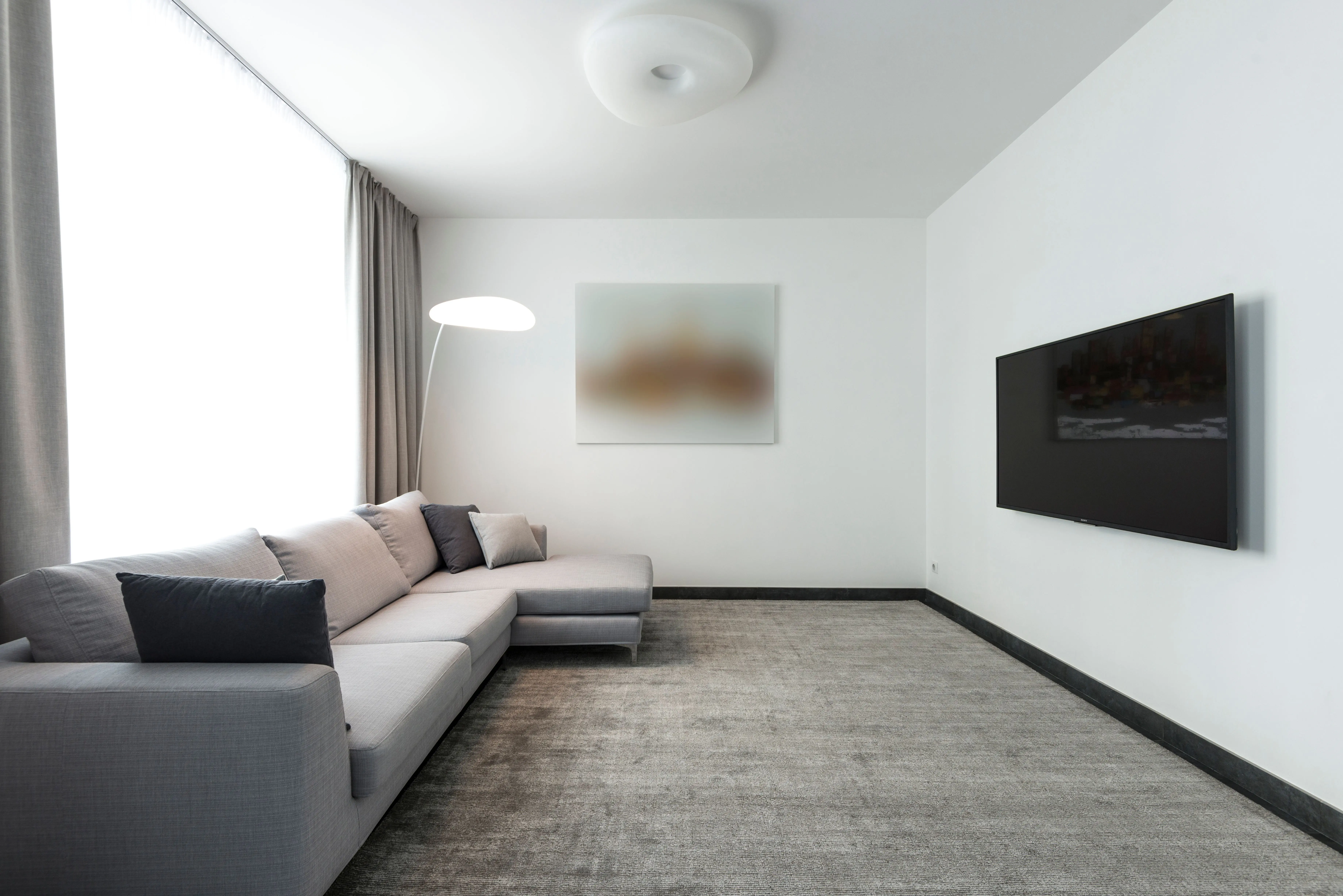 gray sectional Contemporary living room with a gray sectional sofa and a wall-mounted TV.