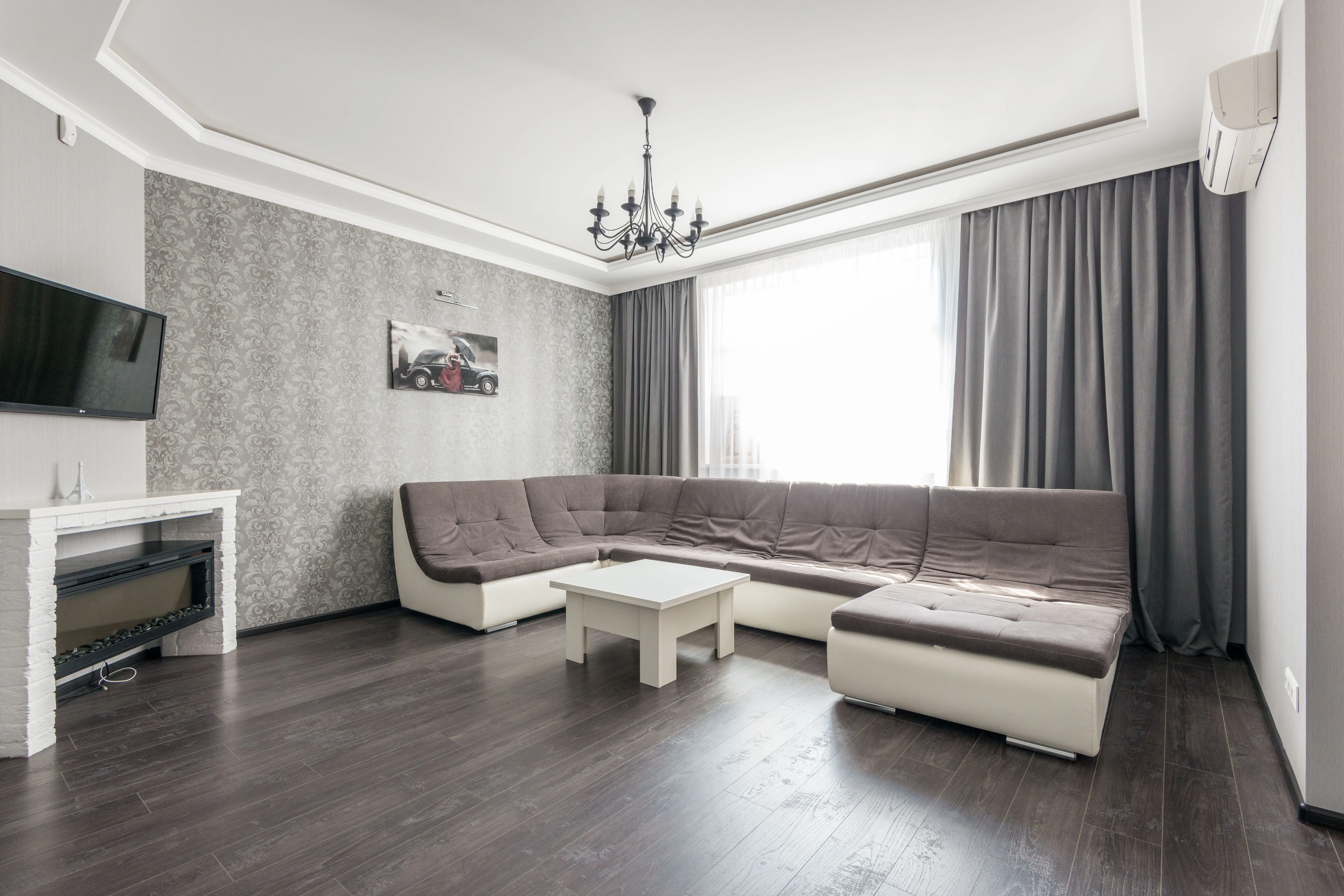 gray sectional Elegant and modern living room interior featuring a large sectional sofa and natural light.