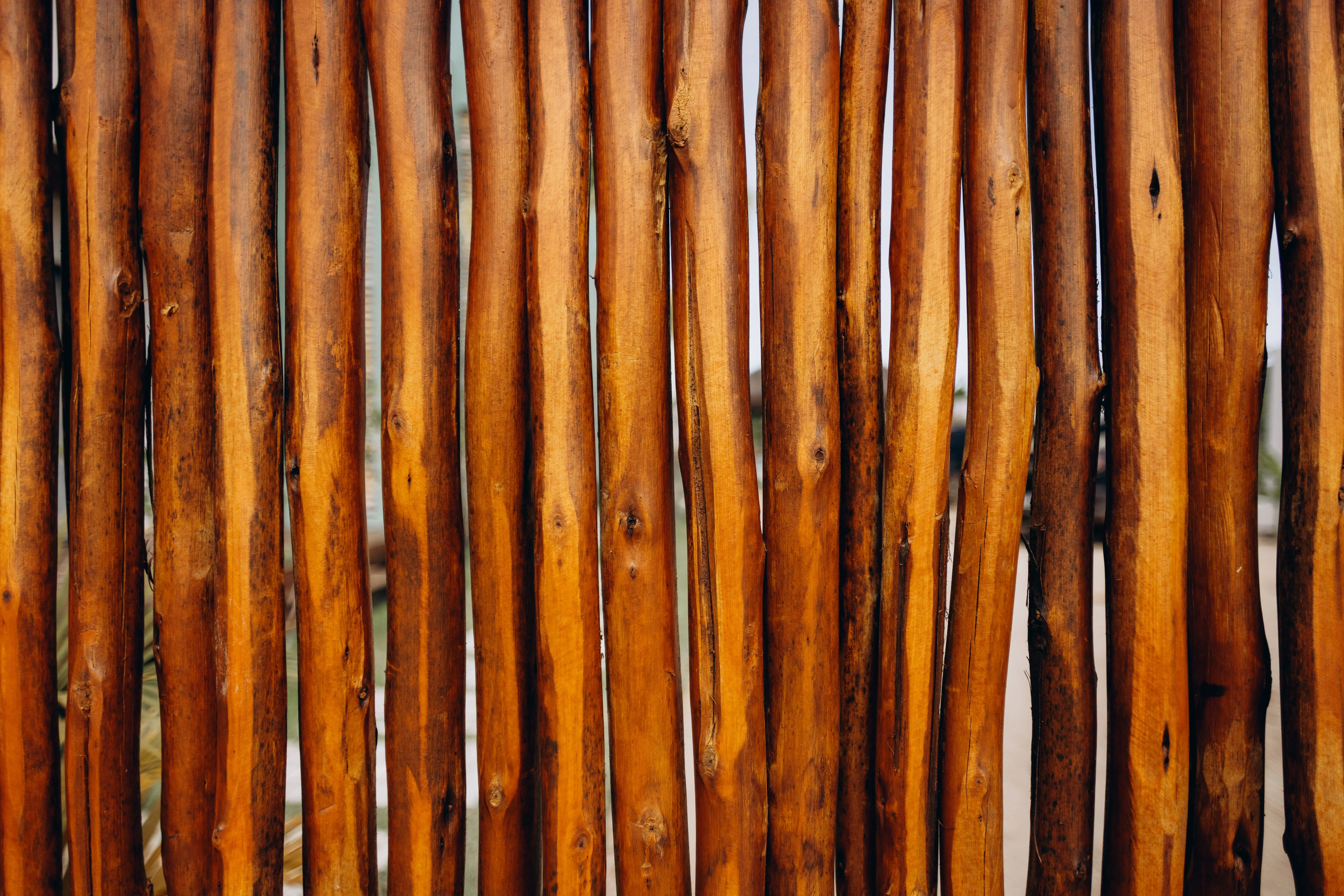 wood fence styles Close-up of a rustic wooden fence showcasing its natural texture and warm tones.