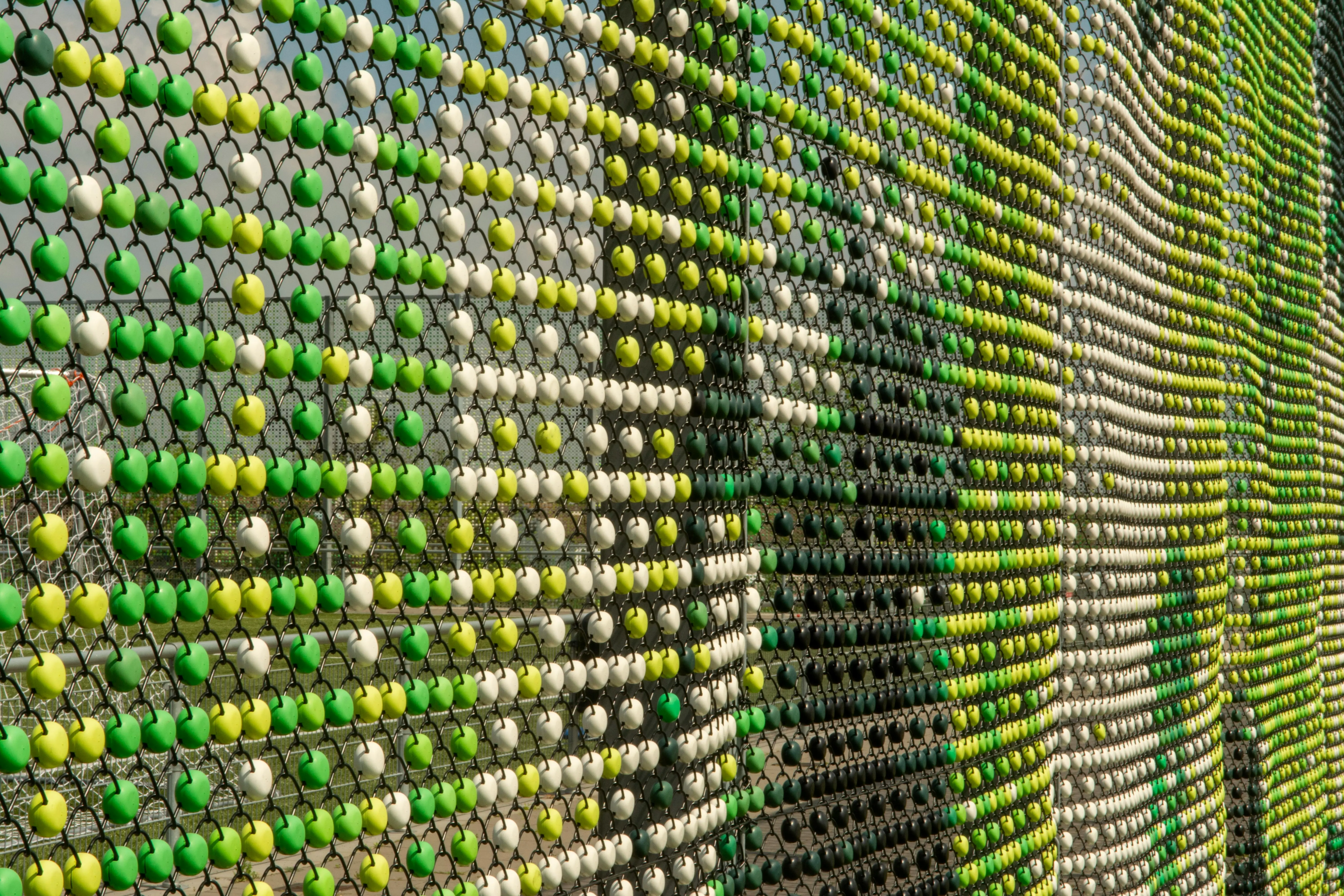colorful art Detailed view of a vibrant urban art installation using colorful balls on a fence.