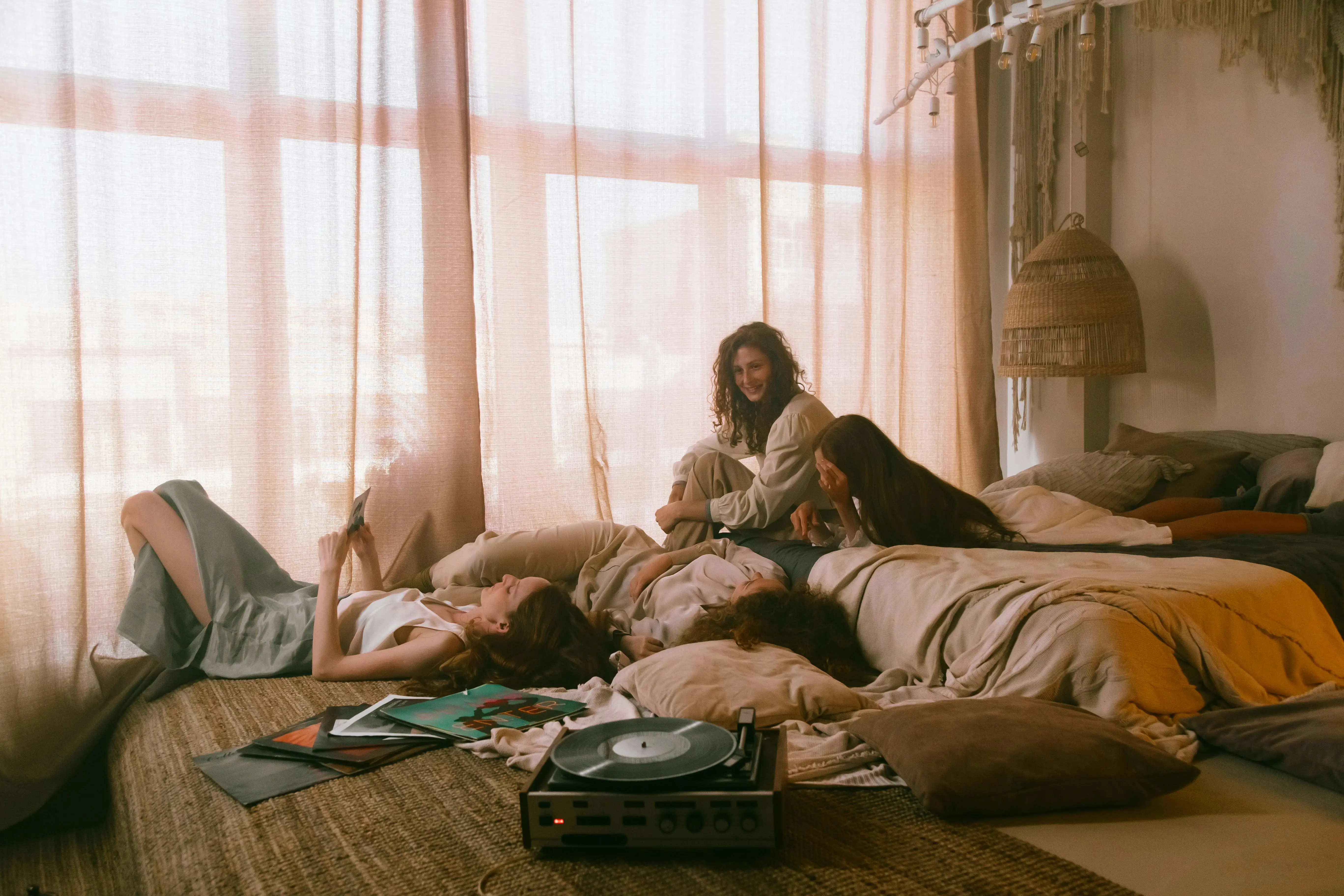 boho comforter set Friends enjoying a cozy indoor gathering, relaxing with music and laughter.