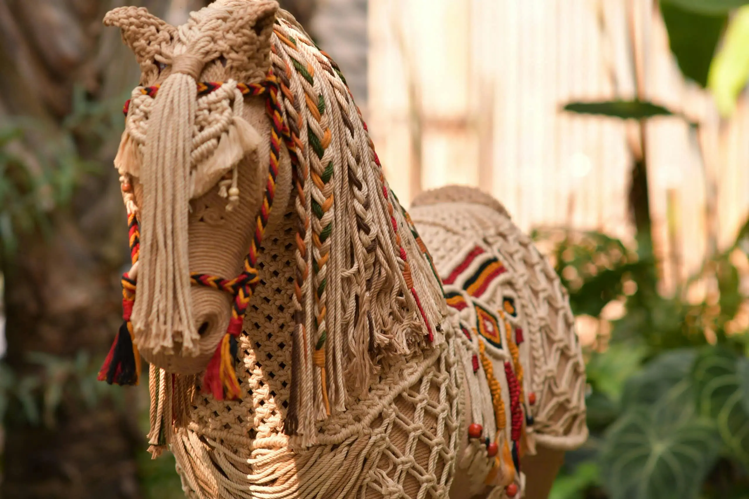 boho comforter set Detailed macrame horse sculpture displayed outdoors with natural greenery.