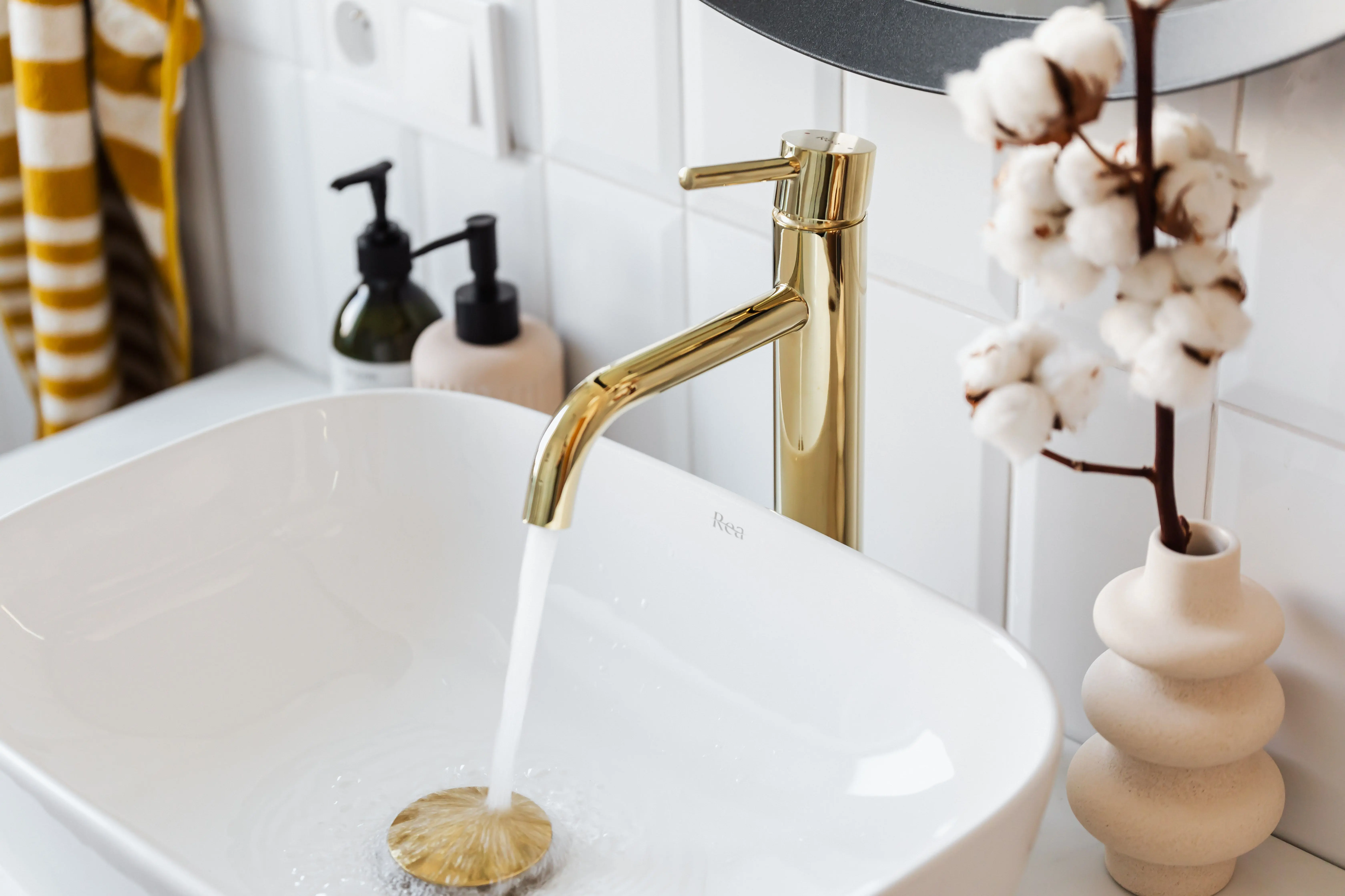gold kitchen hardware A stylish bathroom sink with a modern gold faucet and running water for a touch of luxury.