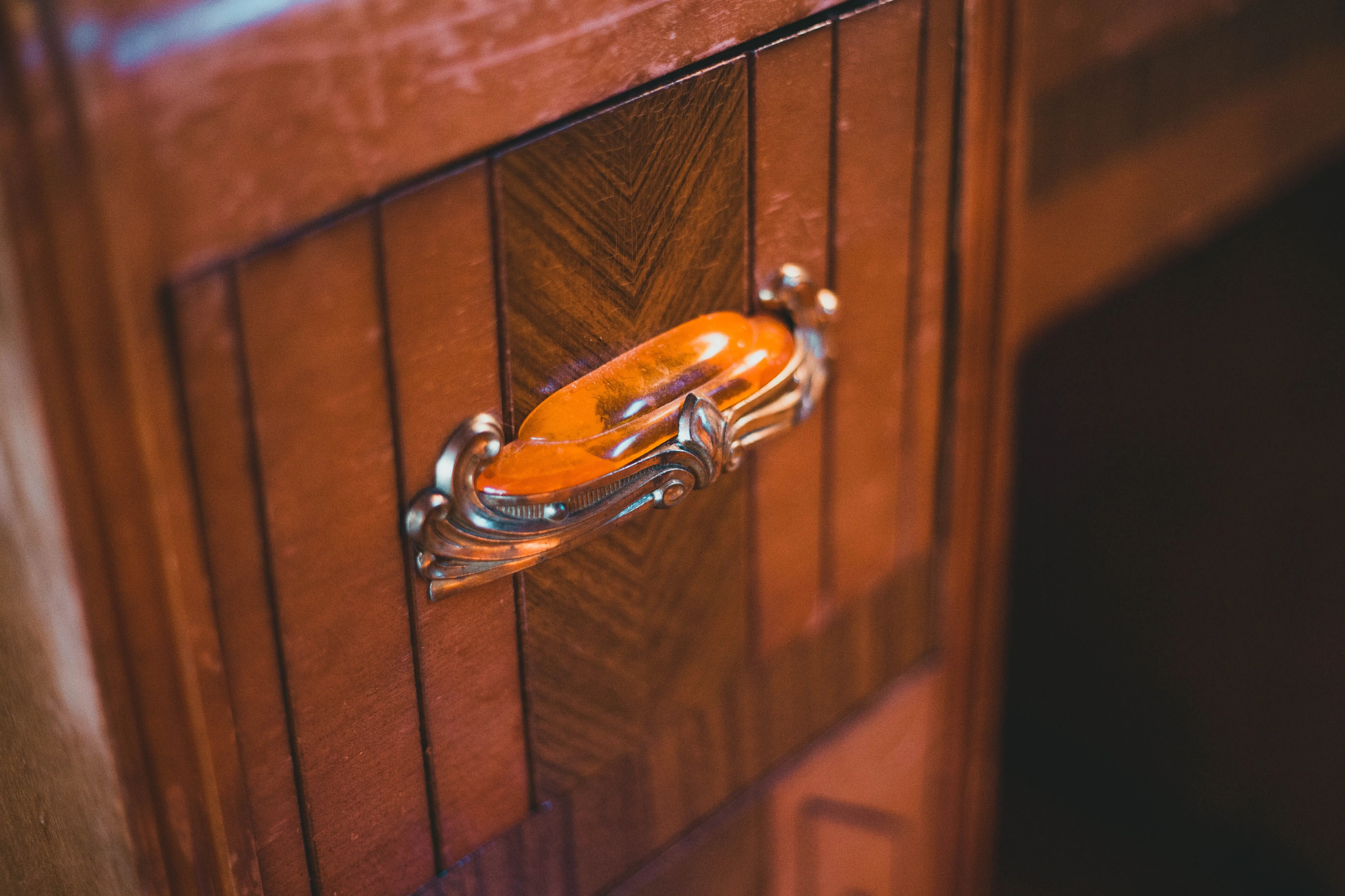 modern kitchen cabinet handles Close-up of a vintage wooden cabinet featuring an ornate retro handle for classic interiors.