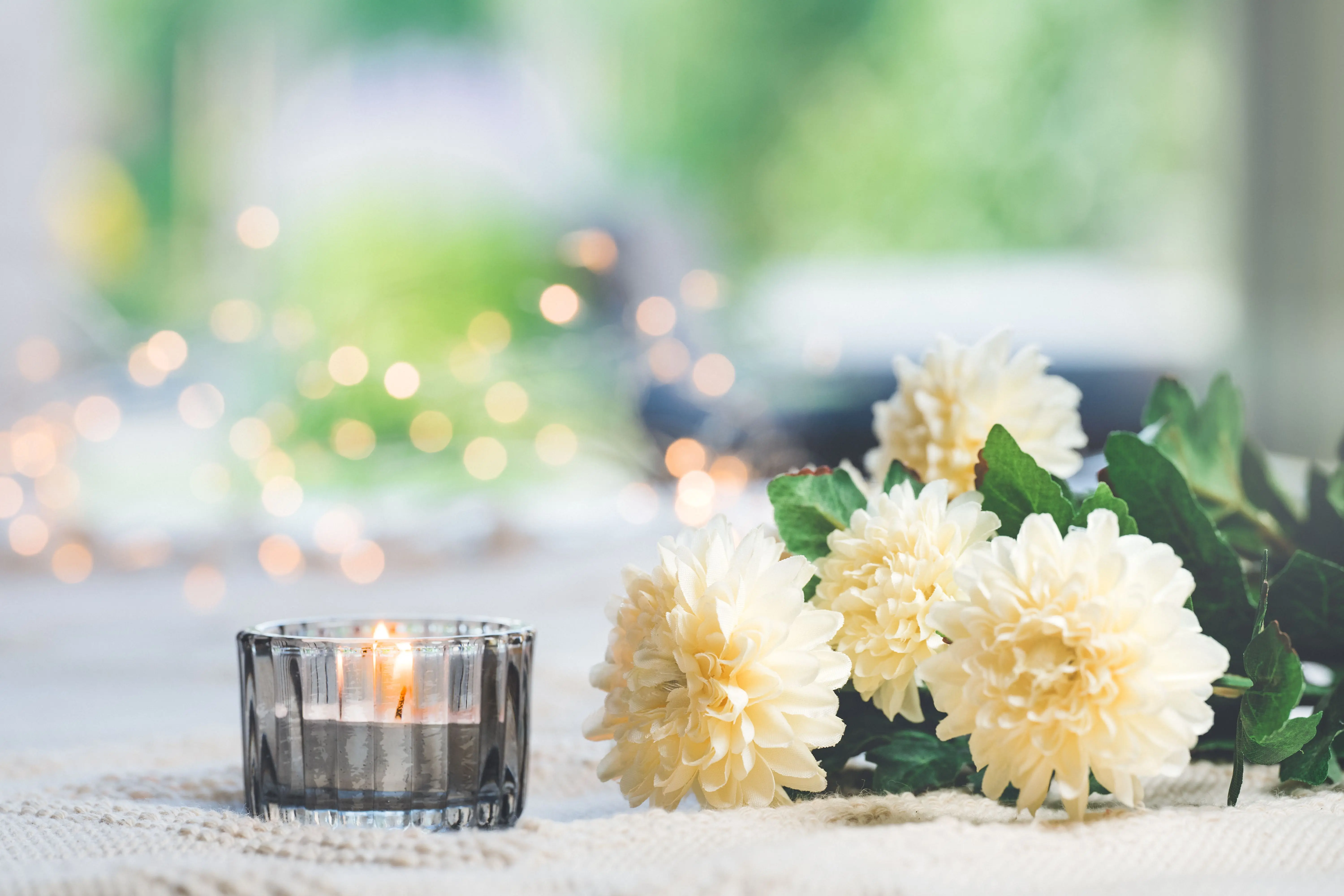 tall candle holders A serene tabletop scene with candlelight and white chrysanthemums, perfect for tranquil moments.