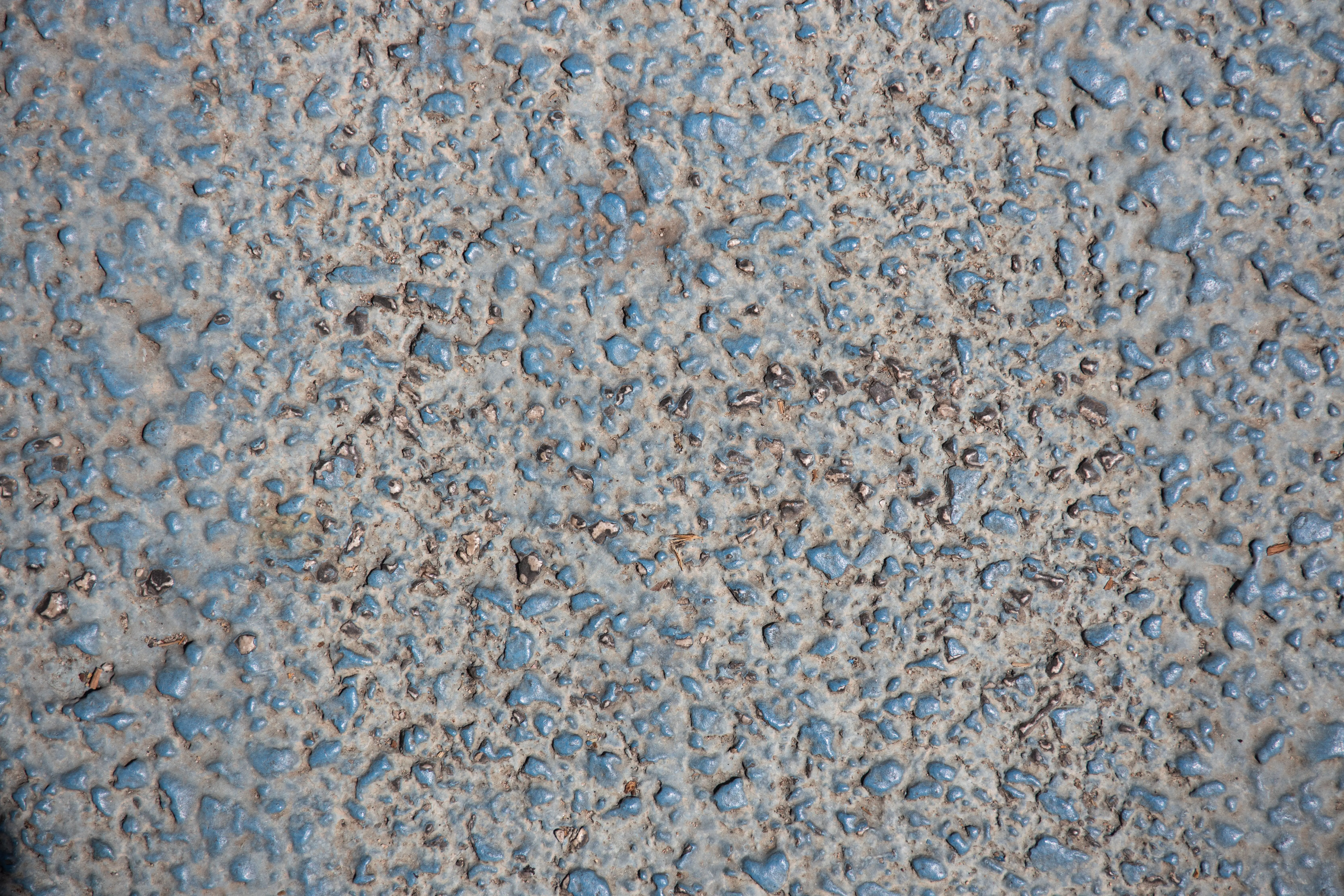 paint for cement floor Close-up of a textured granite surface, showcasing roughness with visible pebbles for background use.