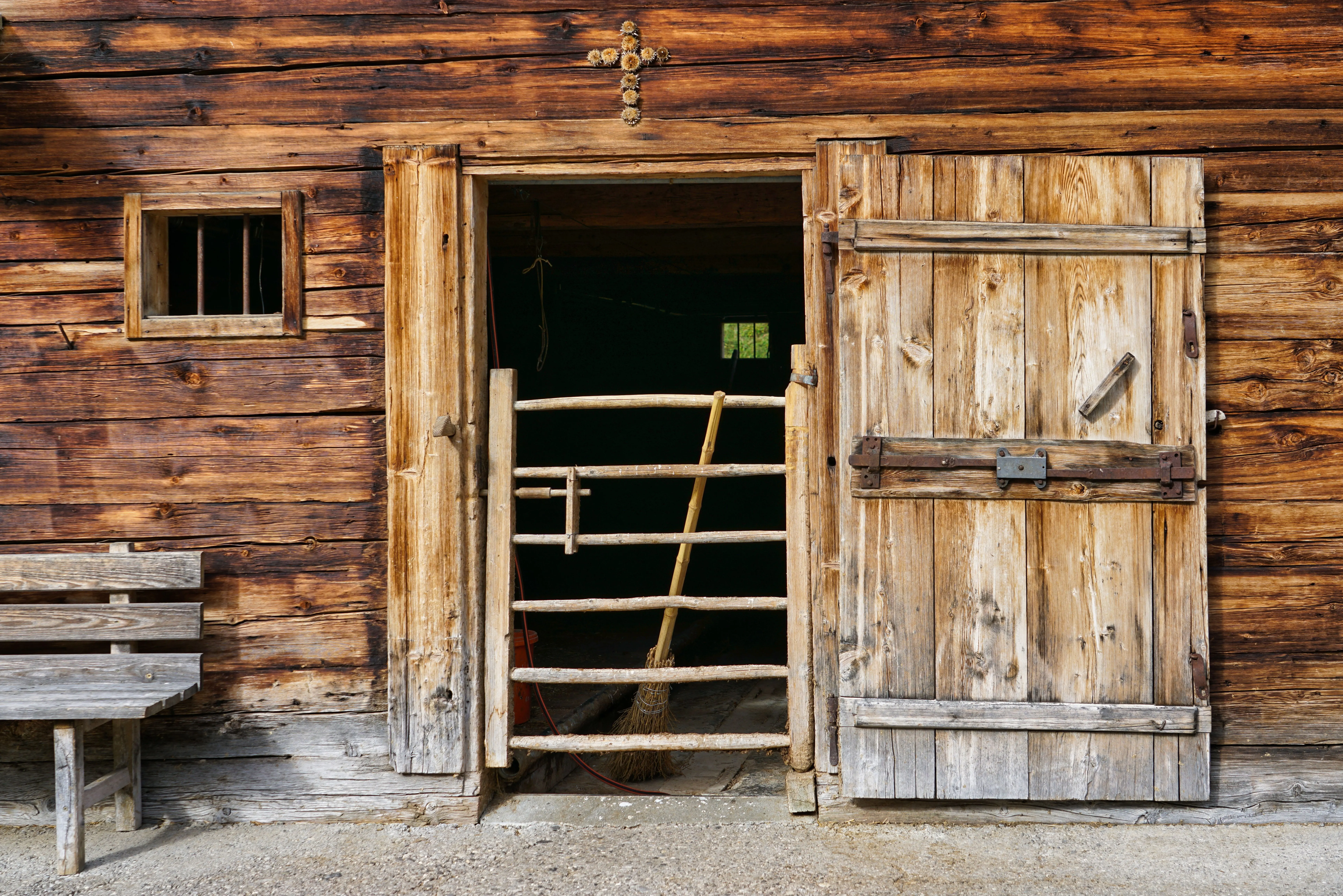 rustic wall decor A rustic wooden barn door opening to a stable interior, captured in a rural setting.