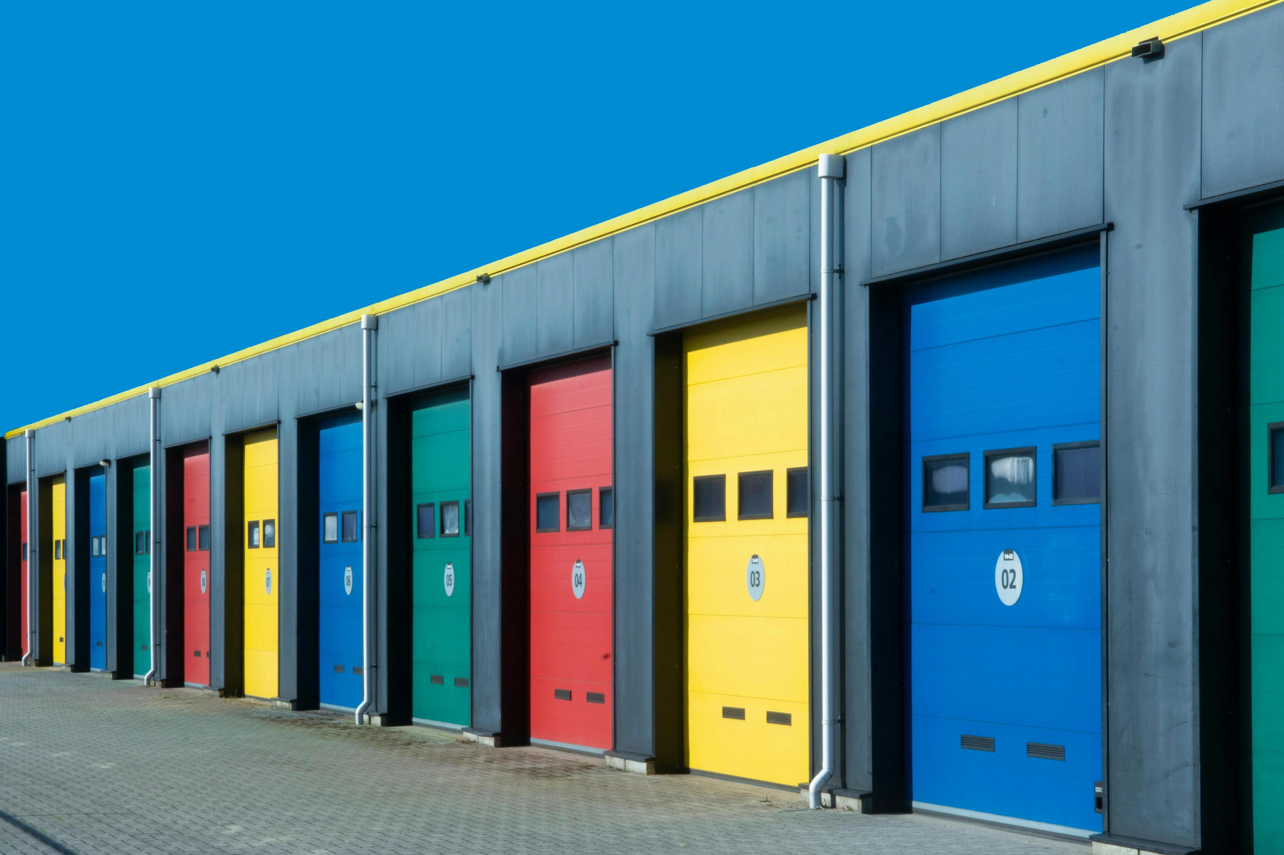black garage door Vibrant row of industrial garage doors in blue, red, yellow, and green, perfect for commercial use.