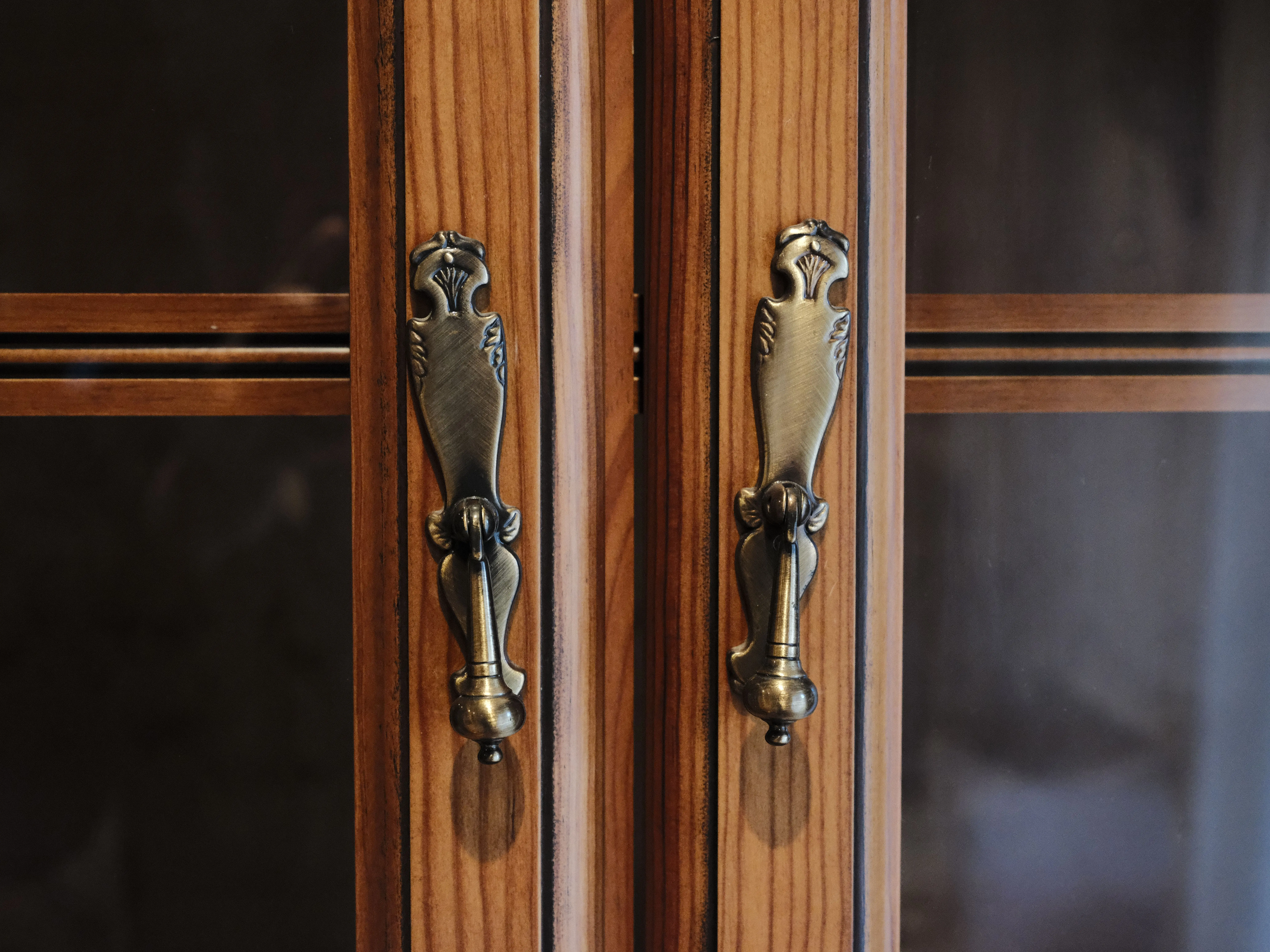 gold kitchen hardware Close-up of elegant brass door handles on a wooden cabinet in Zaragoza, Spain.