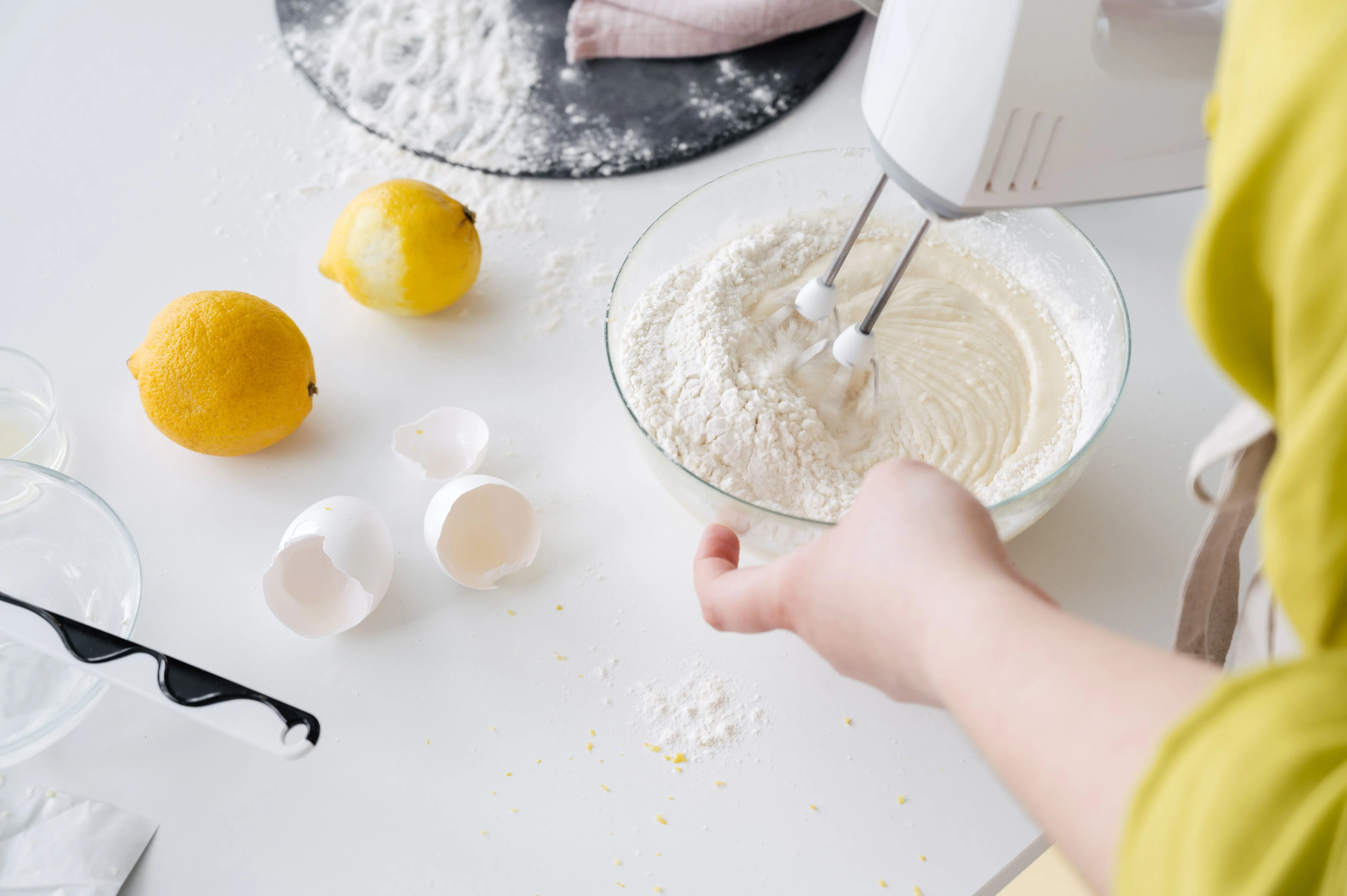 homemade laundry soap From above of crop anonymous female with mixer preparing cake dough at table with fresh lemons and eggshells in house