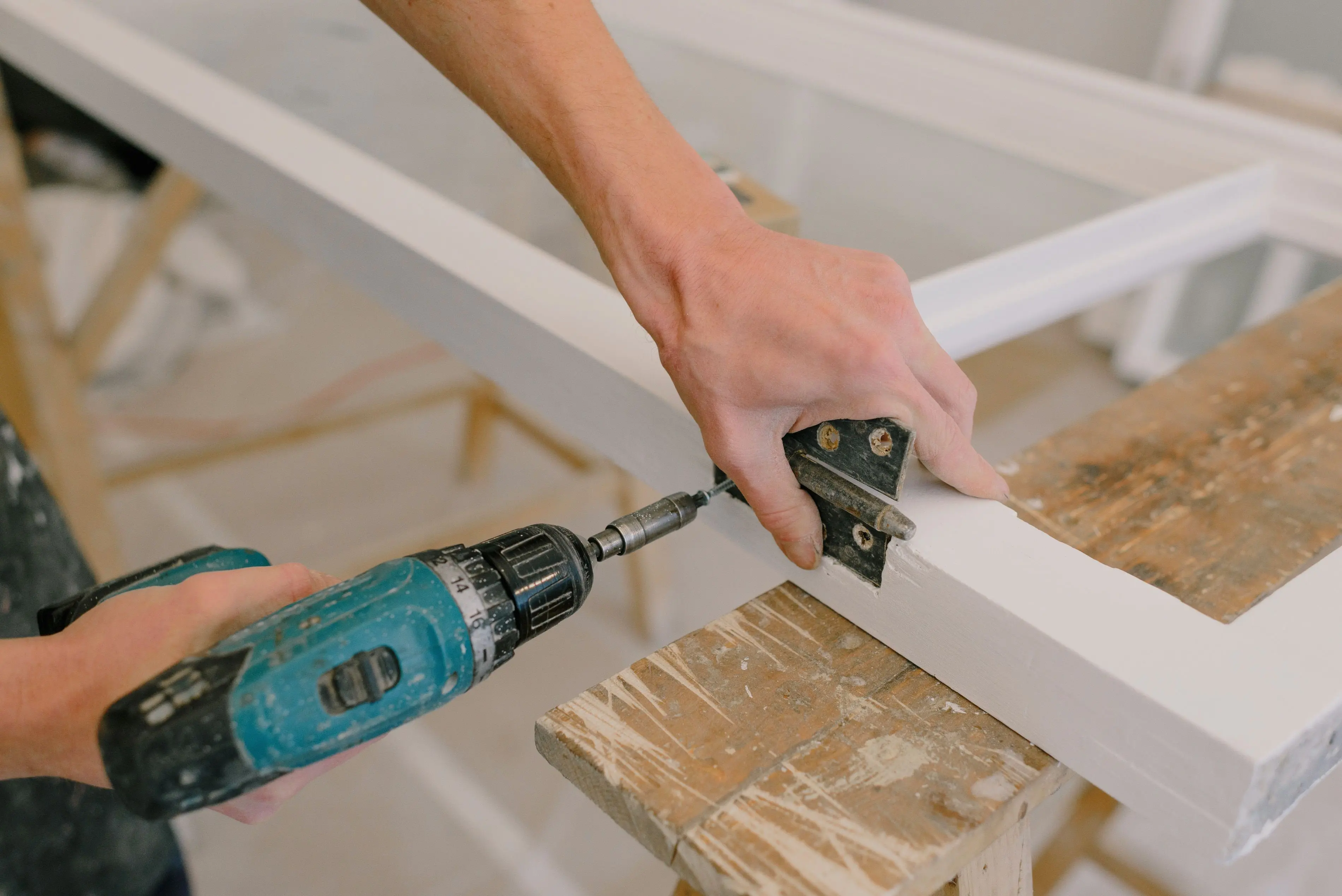 modern kitchen cabinet handles Unrecognizable professional male master using cordless screwdriver to install metal hinge on wooden window in light room during repair works