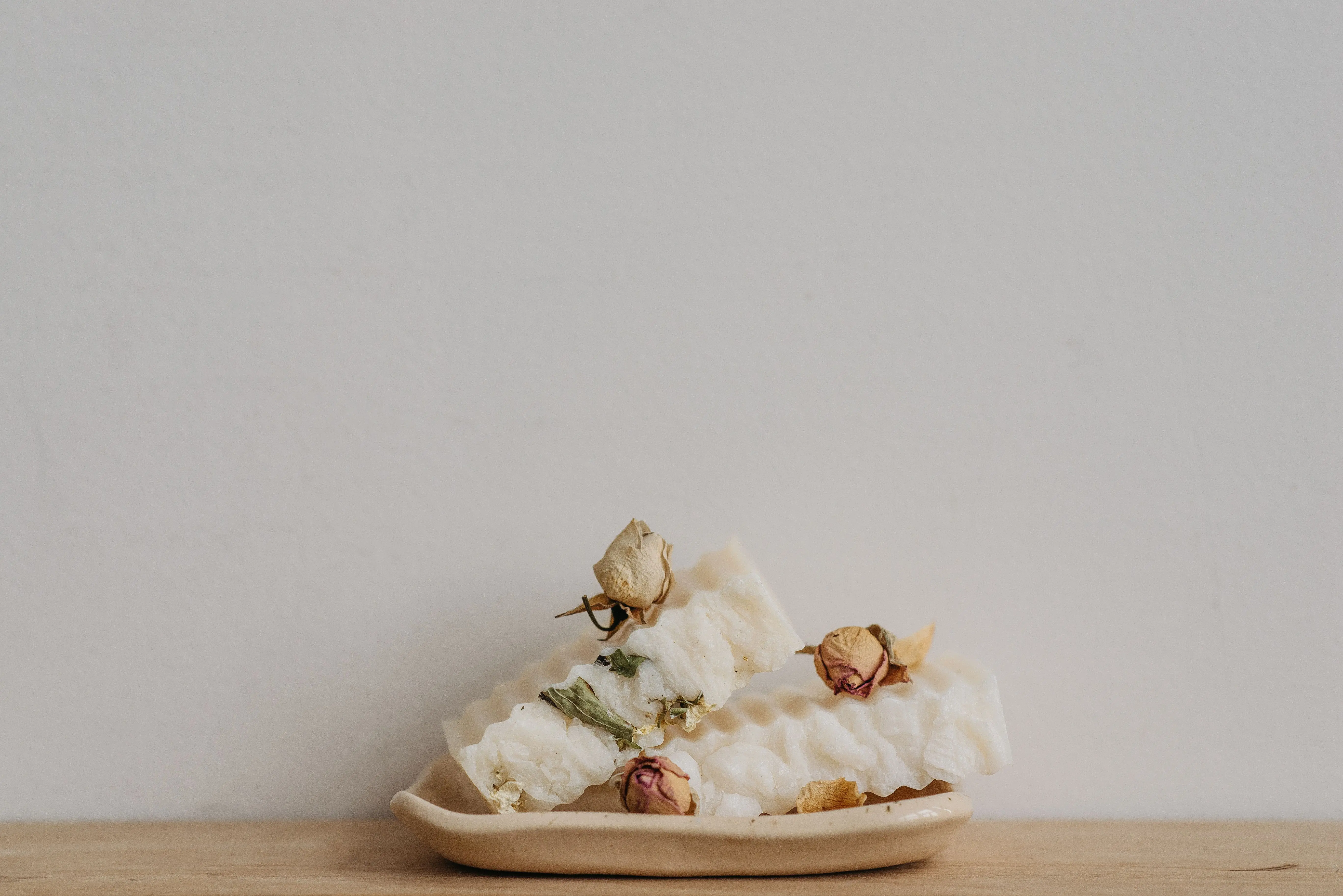 homemade laundry soap Eco-friendly white soap bars with dried flowers on a ceramic tray, perfect for sustainable living.