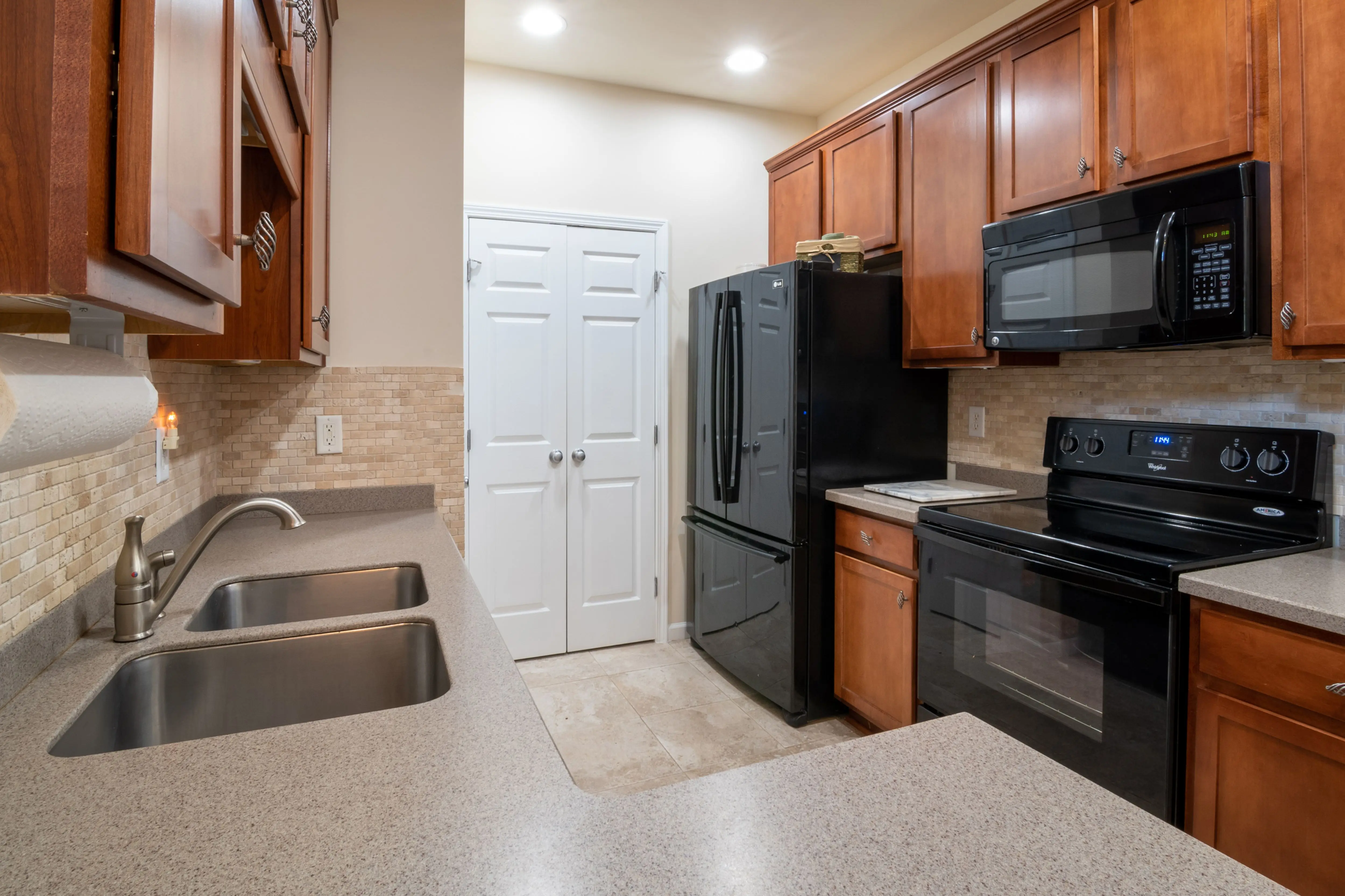 kitchen cabinet with drawers A contemporary kitchen featuring wooden cabinets, modern appliances, and a marble countertop.