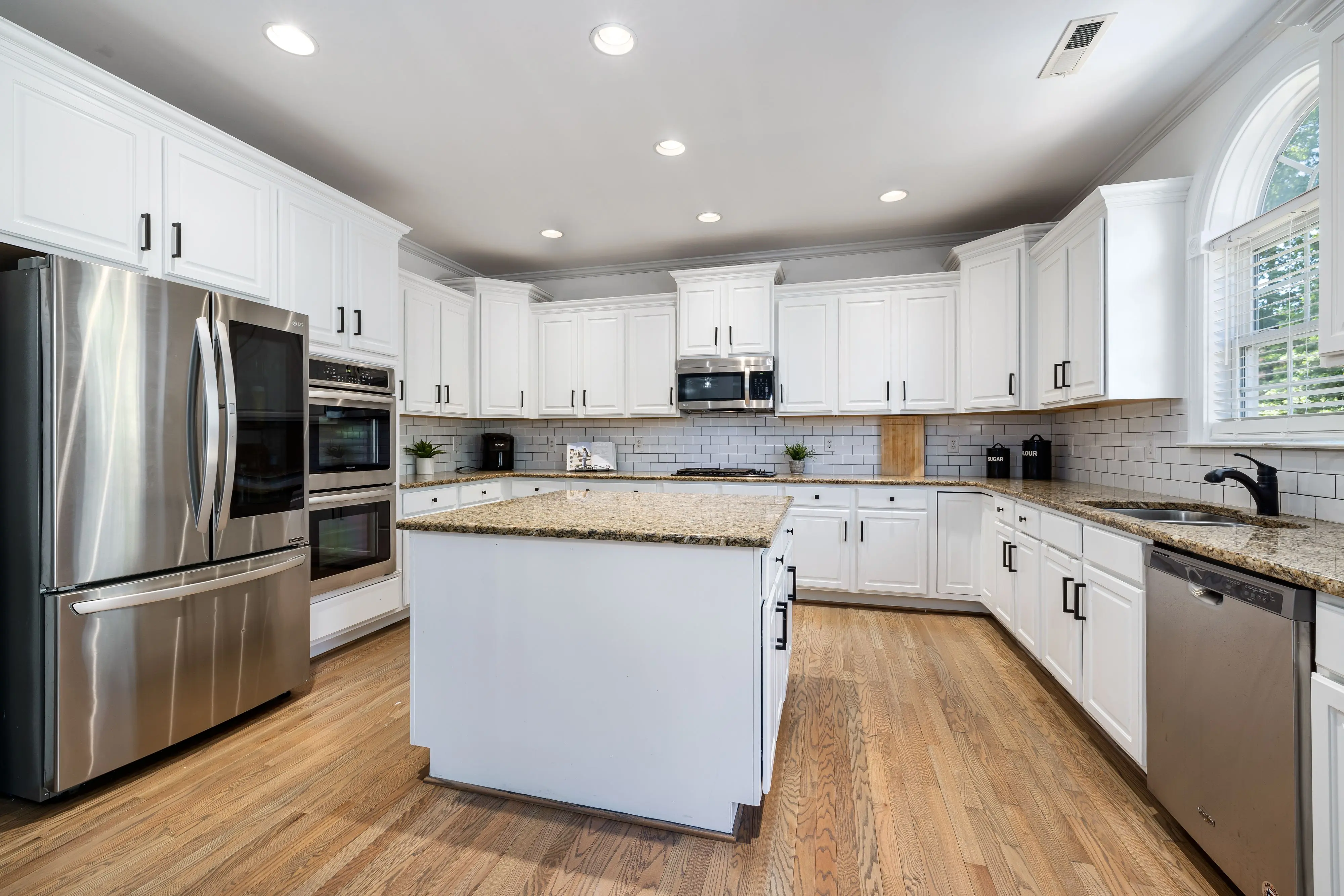 modern kitchen cabinet handles Modern kitchen featuring white cabinets, granite countertops, and stainless steel appliances.