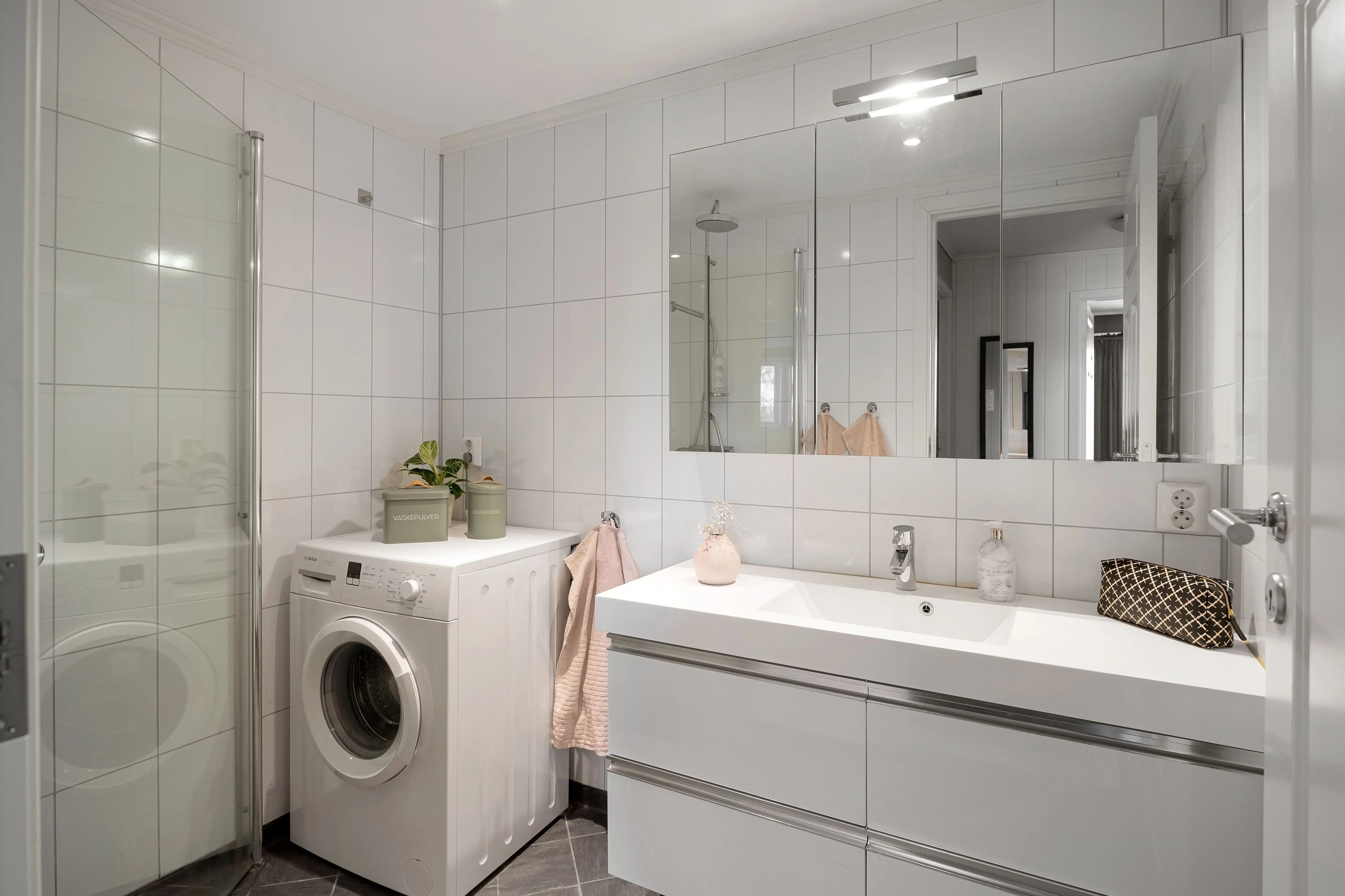 bathroom wall accessories Stylish bathroom featuring a washing machine and sleek interior design elements.