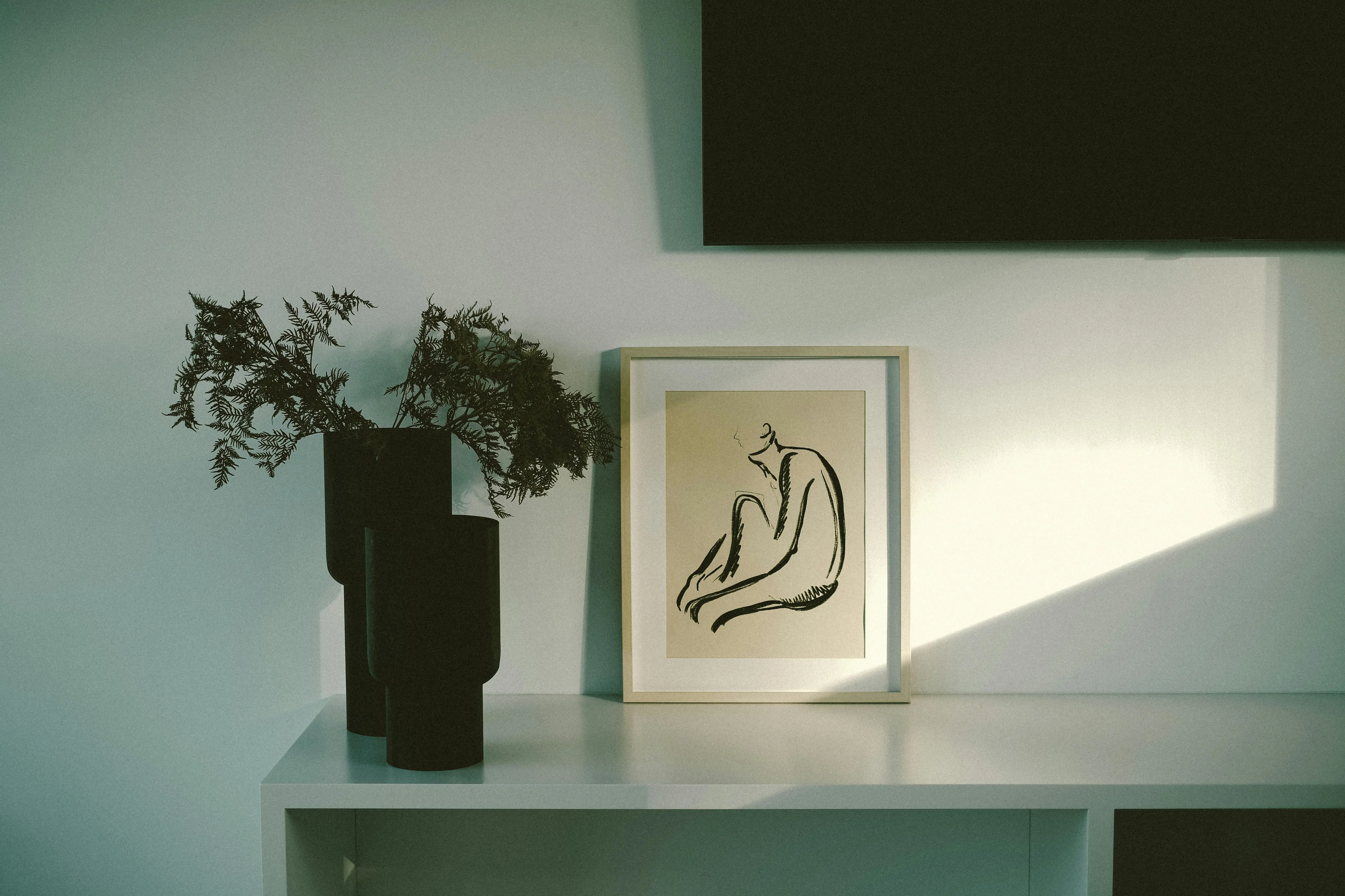 colorful art Cozy minimalist interior with abstract art and vases on a shelf.