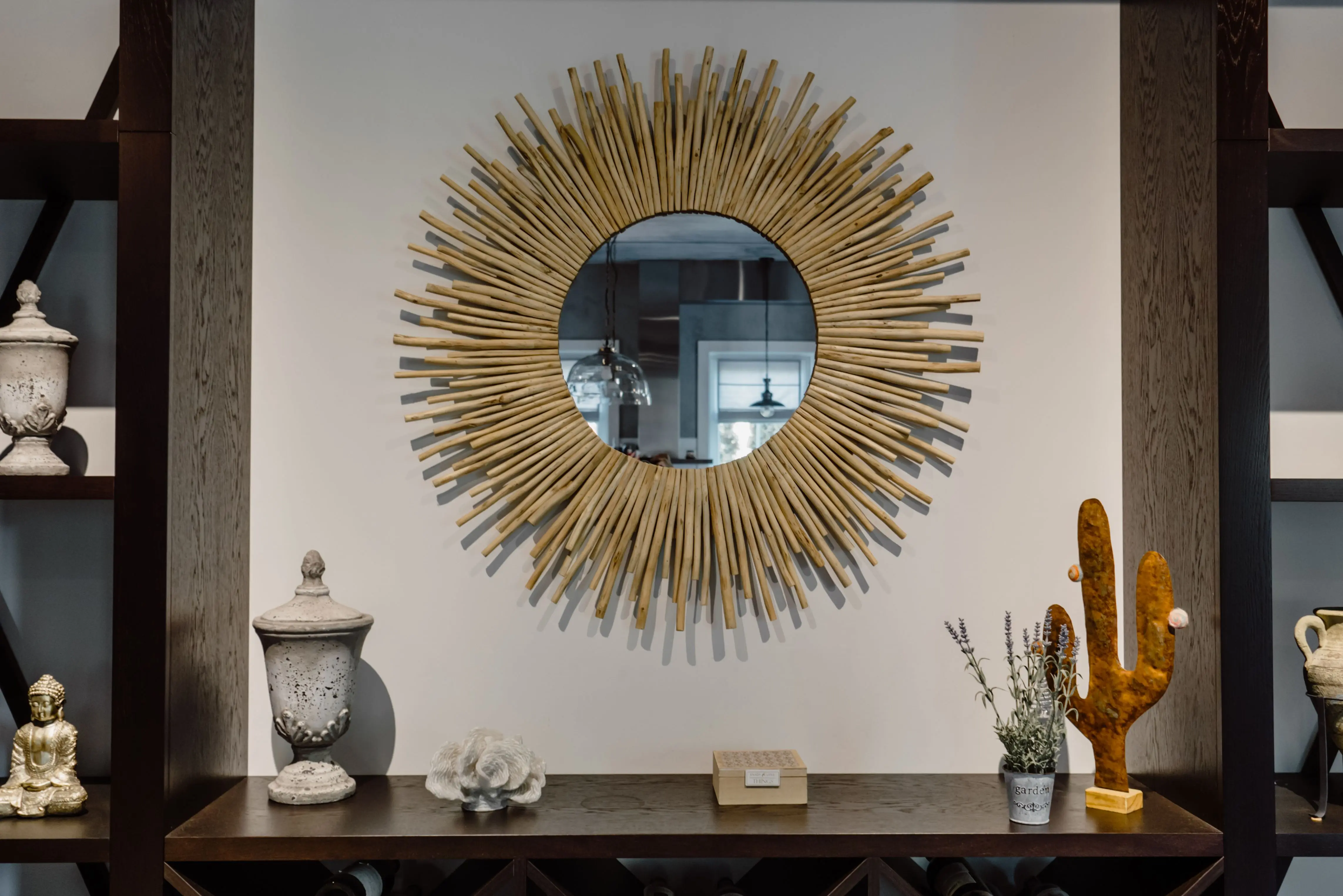 rustic wall decor Contemporary living room featuring a unique sunburst mirror and chic decor accents.