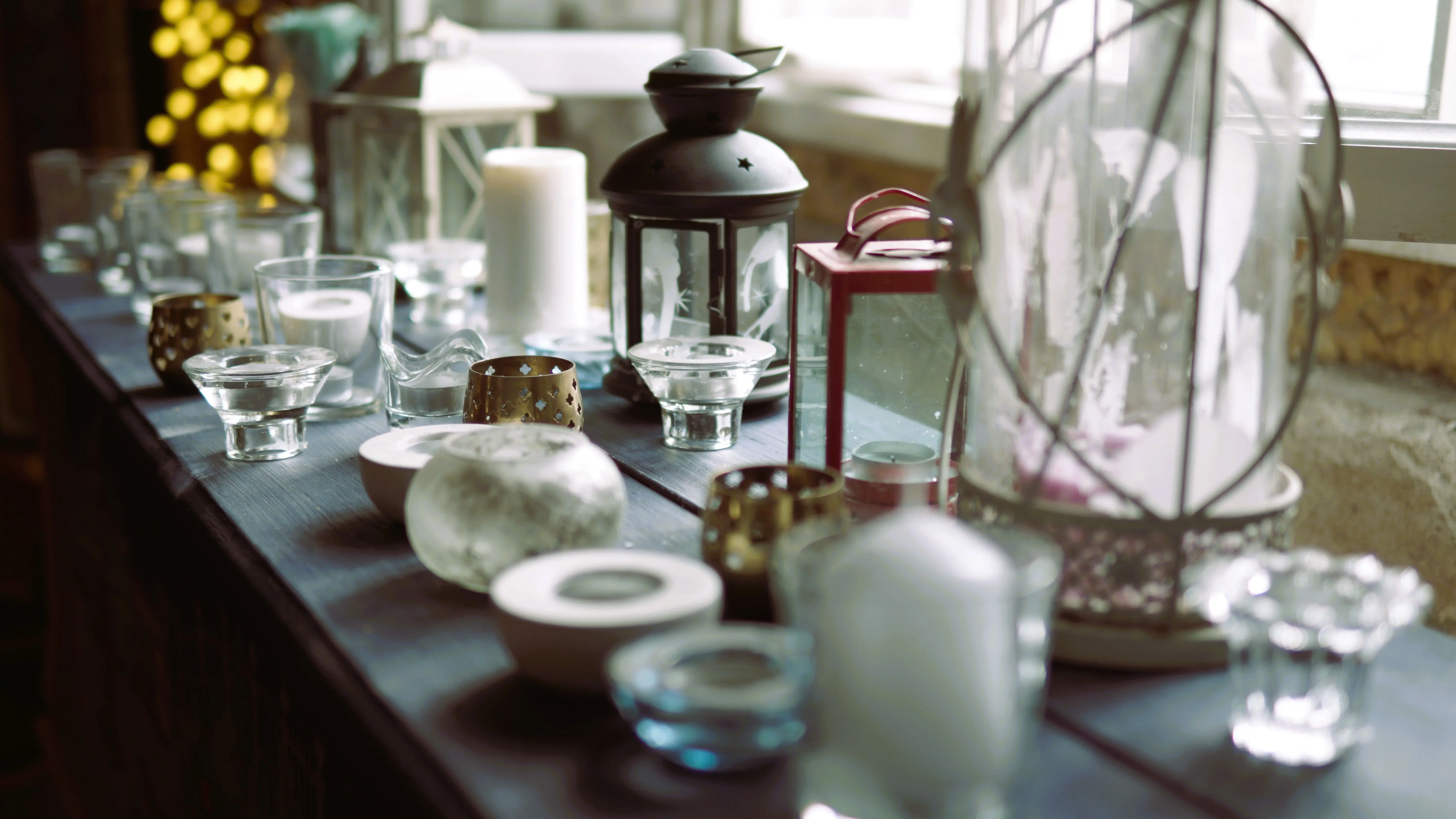 tall candle holders Aesthetic indoor setting with various candles and lanterns on a windowsill, creating a warm ambiance.