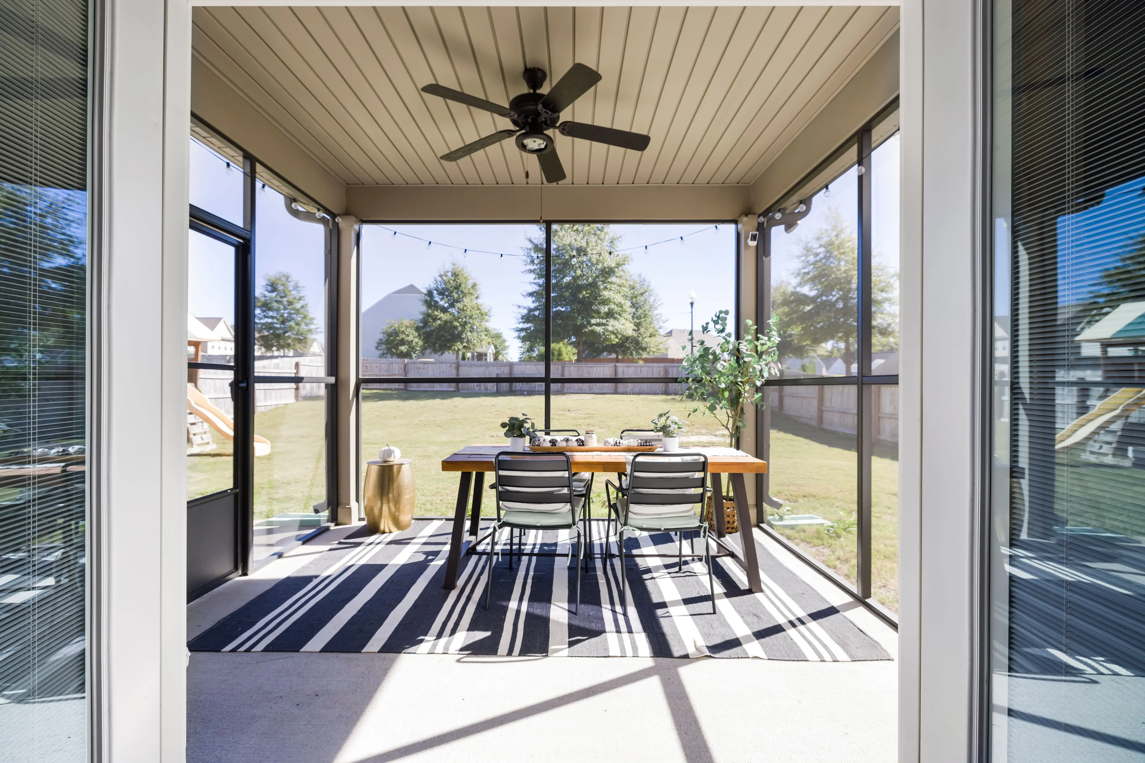 outdoor runner rug A bright and inviting terrace with dining table and chairs, overlooking a sunny garden.