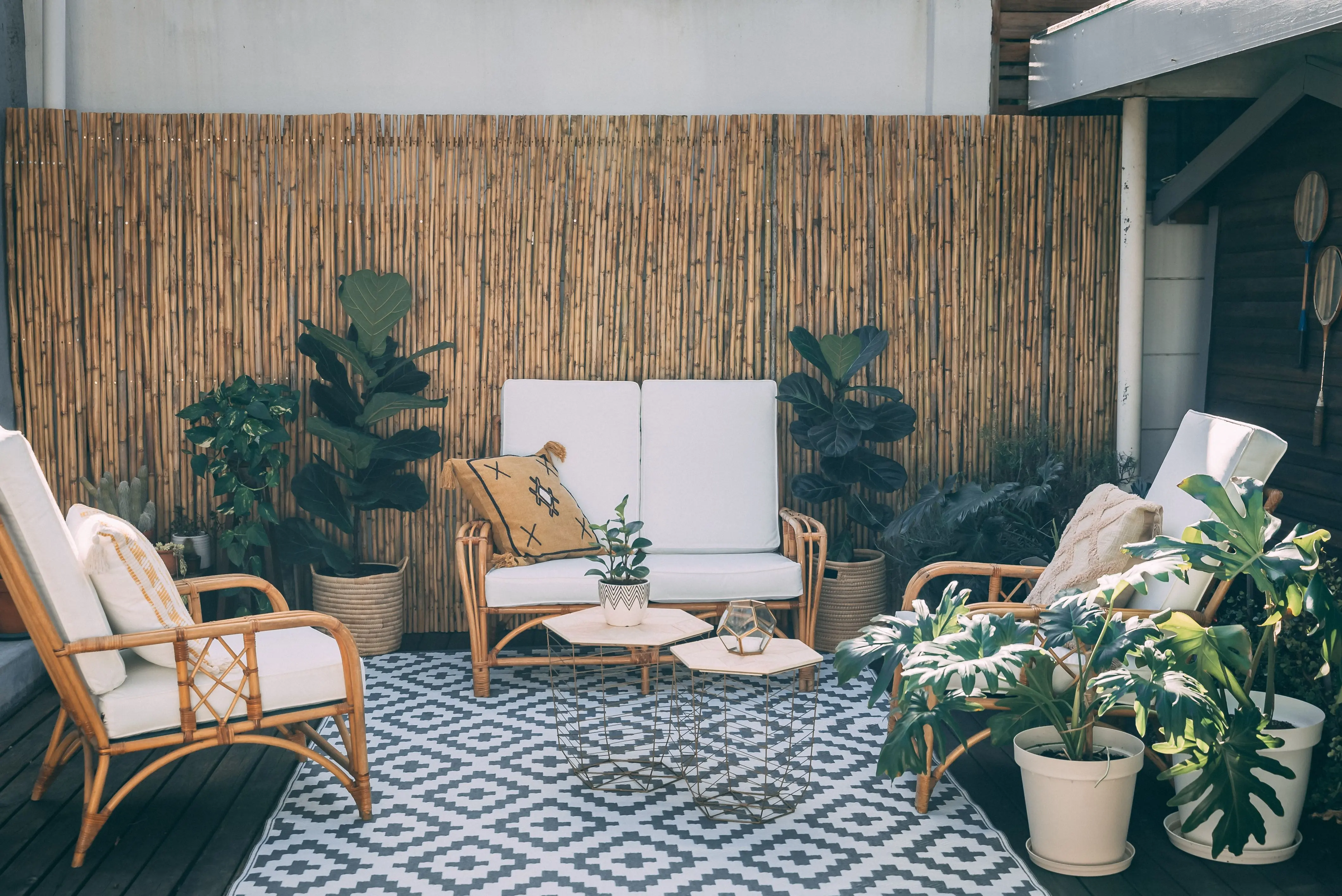 outdoor runner rug Serene outdoor patio featuring rattan furniture, potted plants, and bamboo decor.