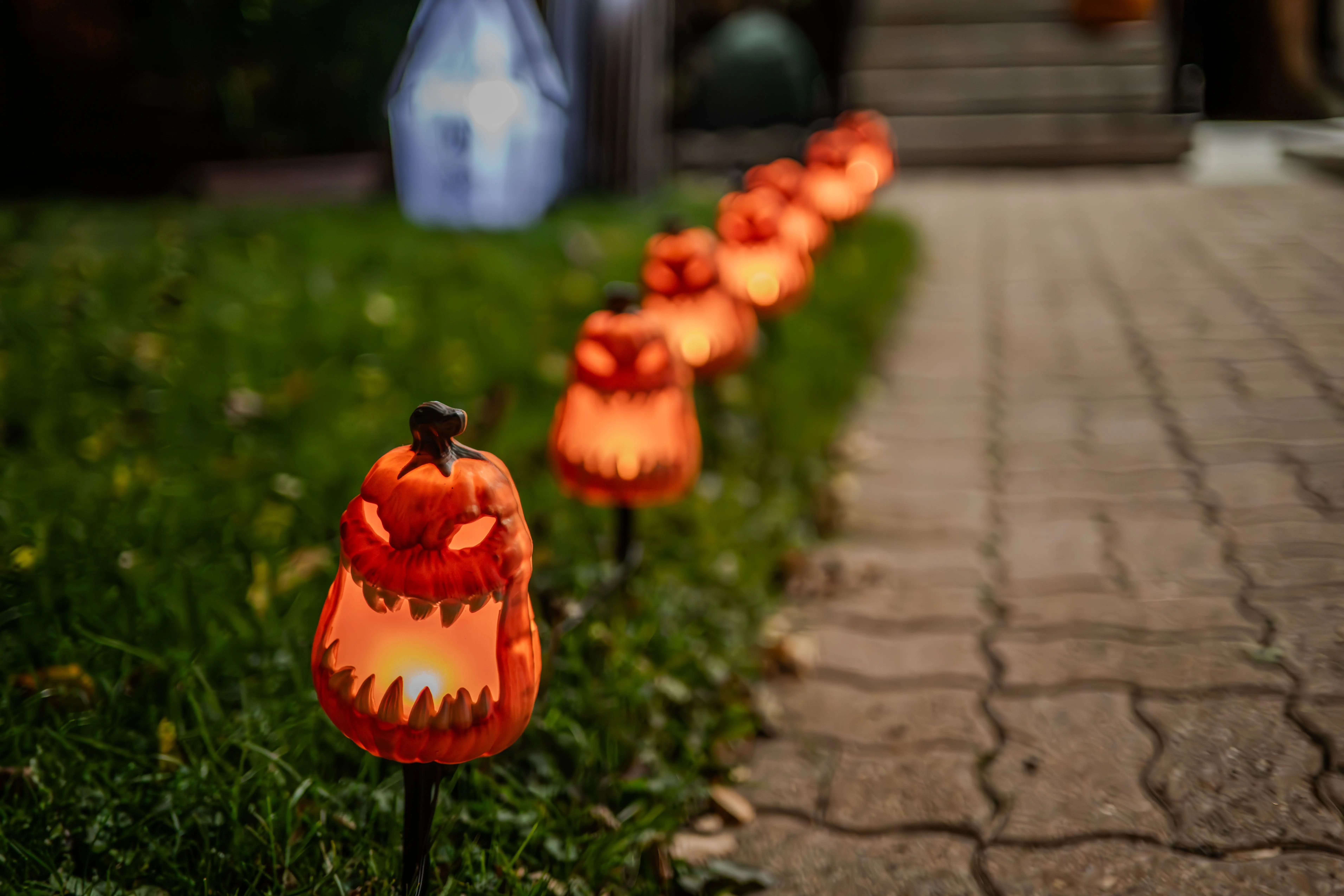path lighting Line of illuminated pumpkin decorations along a garden path, perfect for Halloween ambiance.