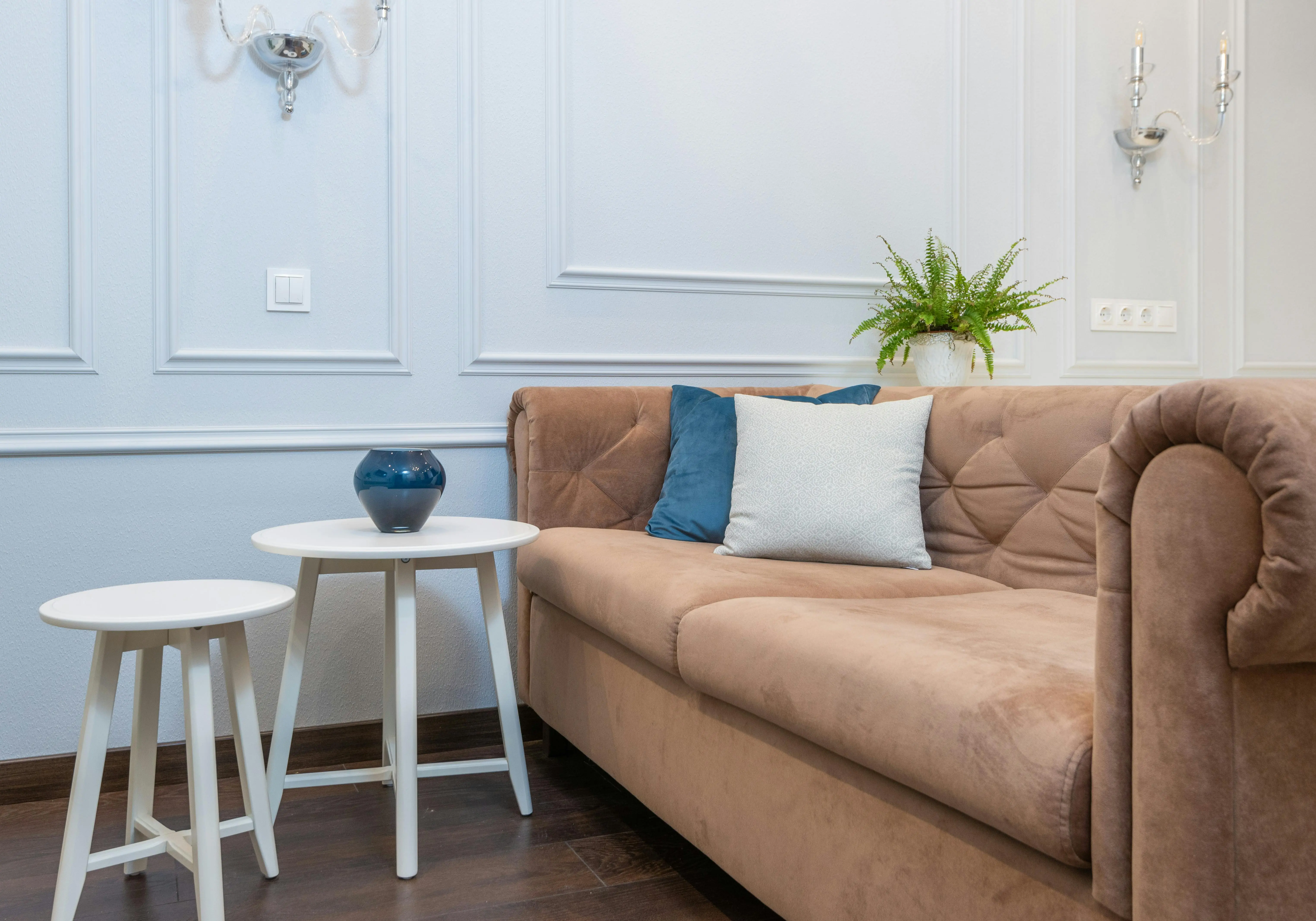 blue accent pillows A cozy living room featuring a stylish sofa, pillows, and a white coffee table, perfect for relaxation.