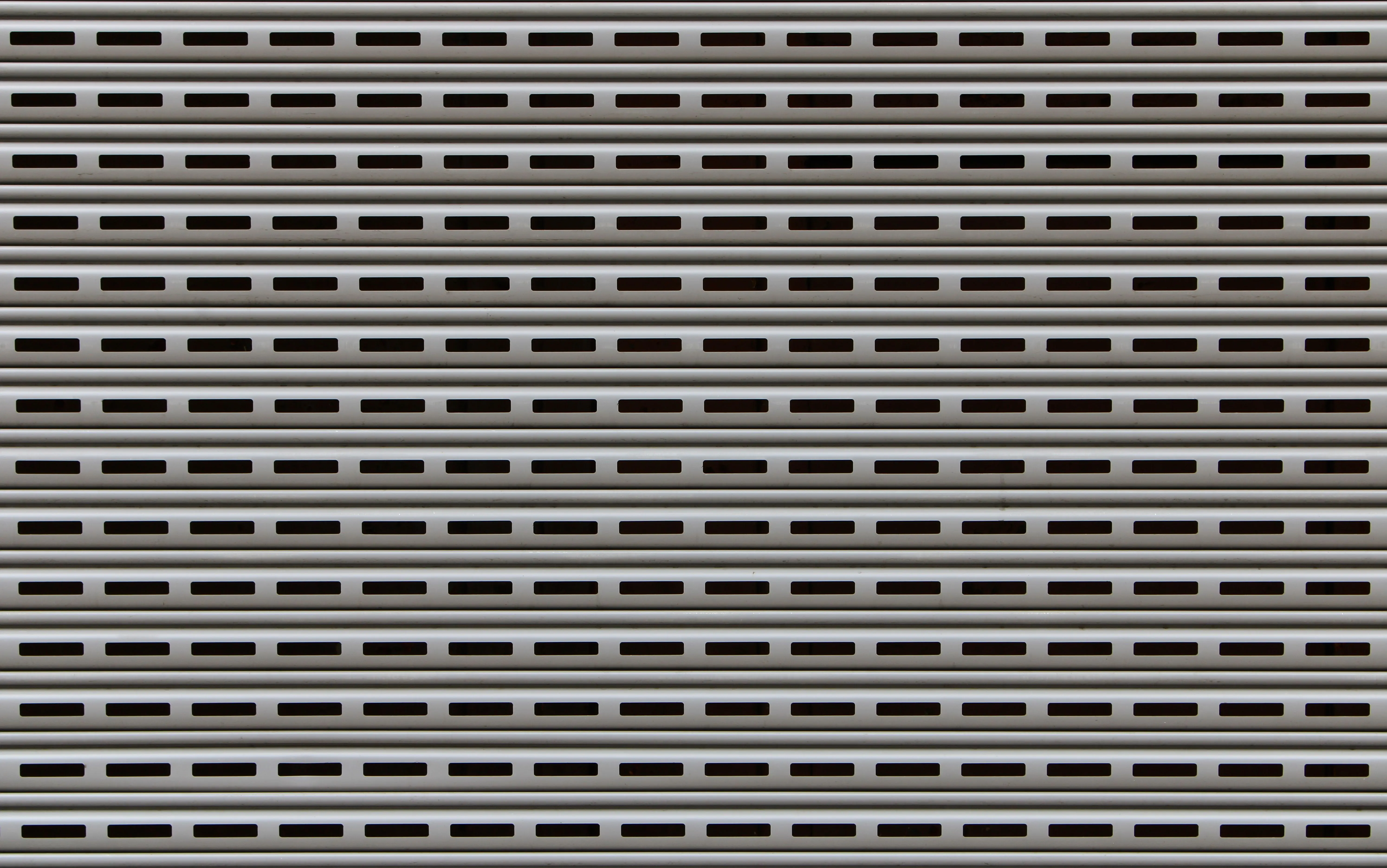black garage door Close-up view of a textured metallic roll-up door showcasing repetitive horizontal patterns.