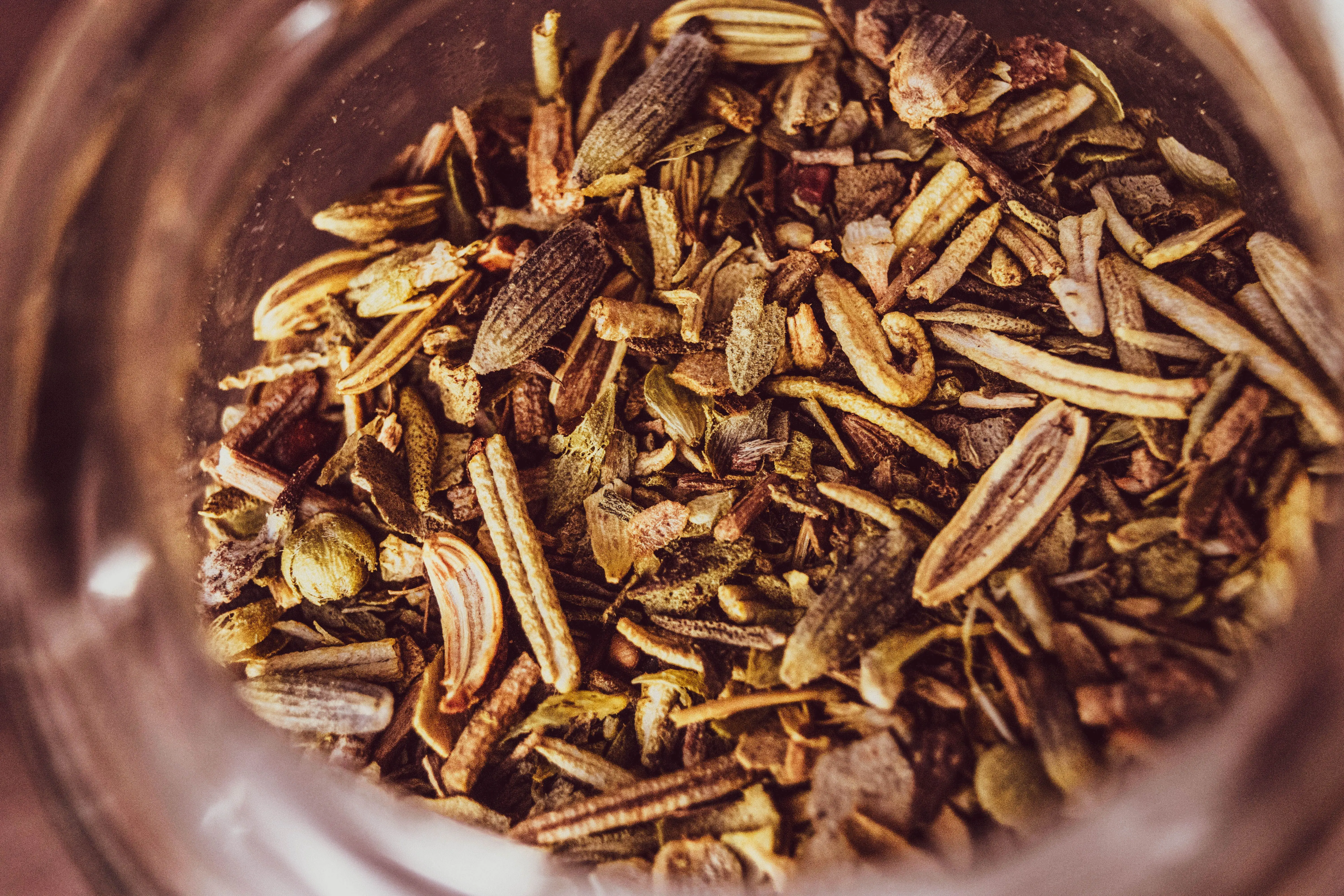thyme seeds A macro shot of an assortment of dried herbs and spices in a jar, showcasing texture and color.