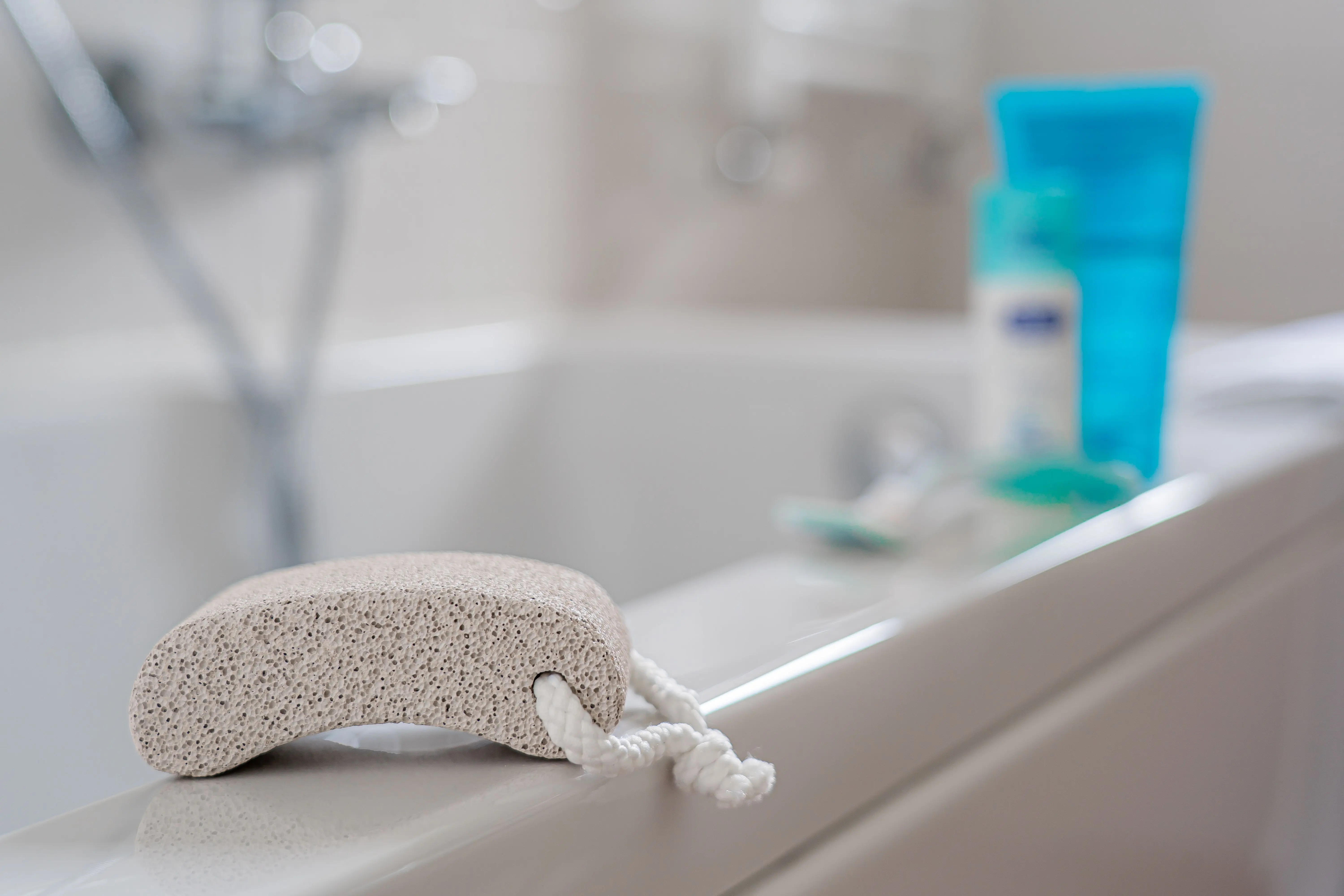 tile floor scrubber machine A pumice stone placed on a bathtub edge, ideal for foot care in a contemporary bathroom setting.