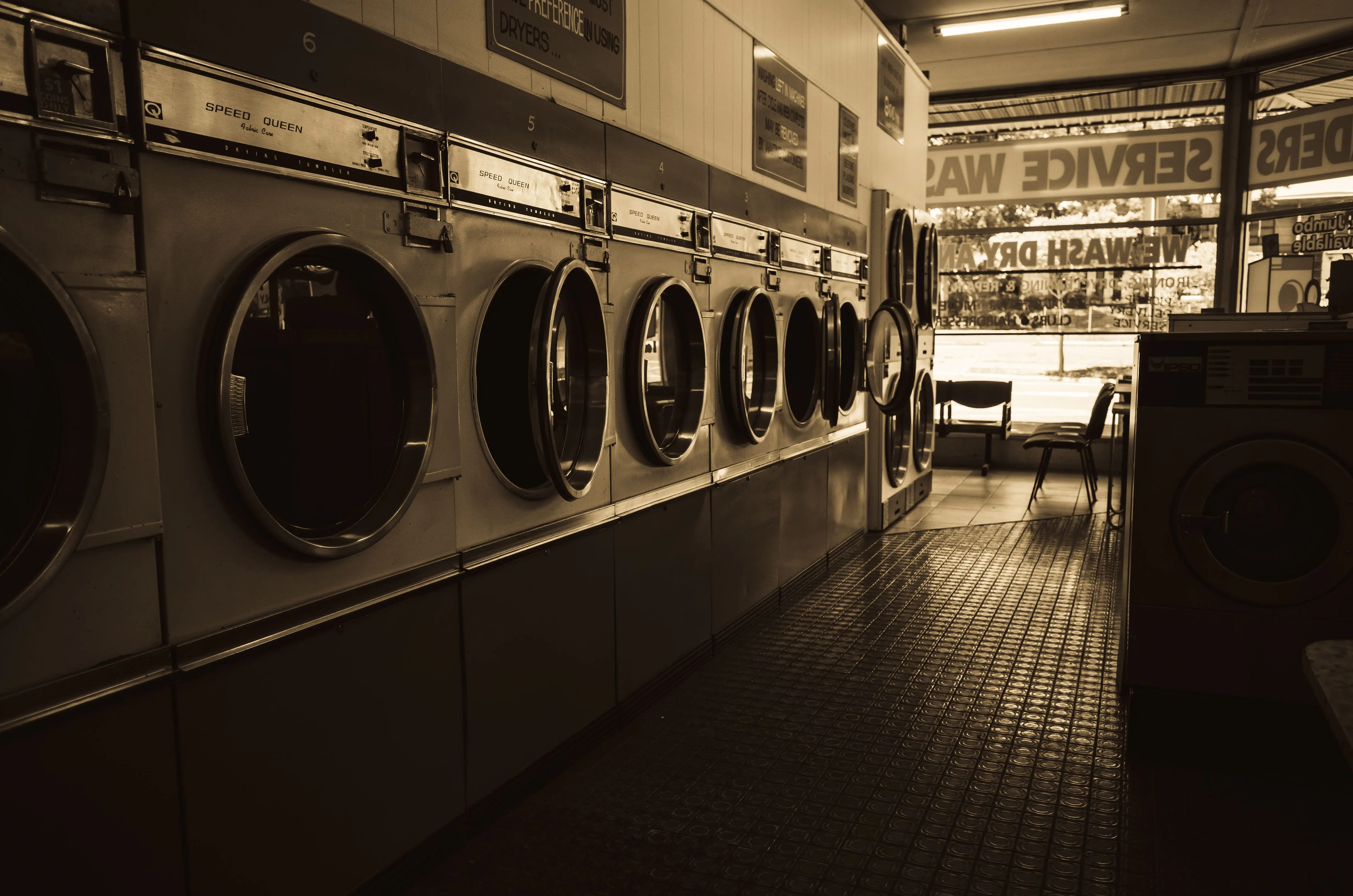 heavy duty washer Sepia-toned image of a laundromat interior showcasing a row of classic washing machines.