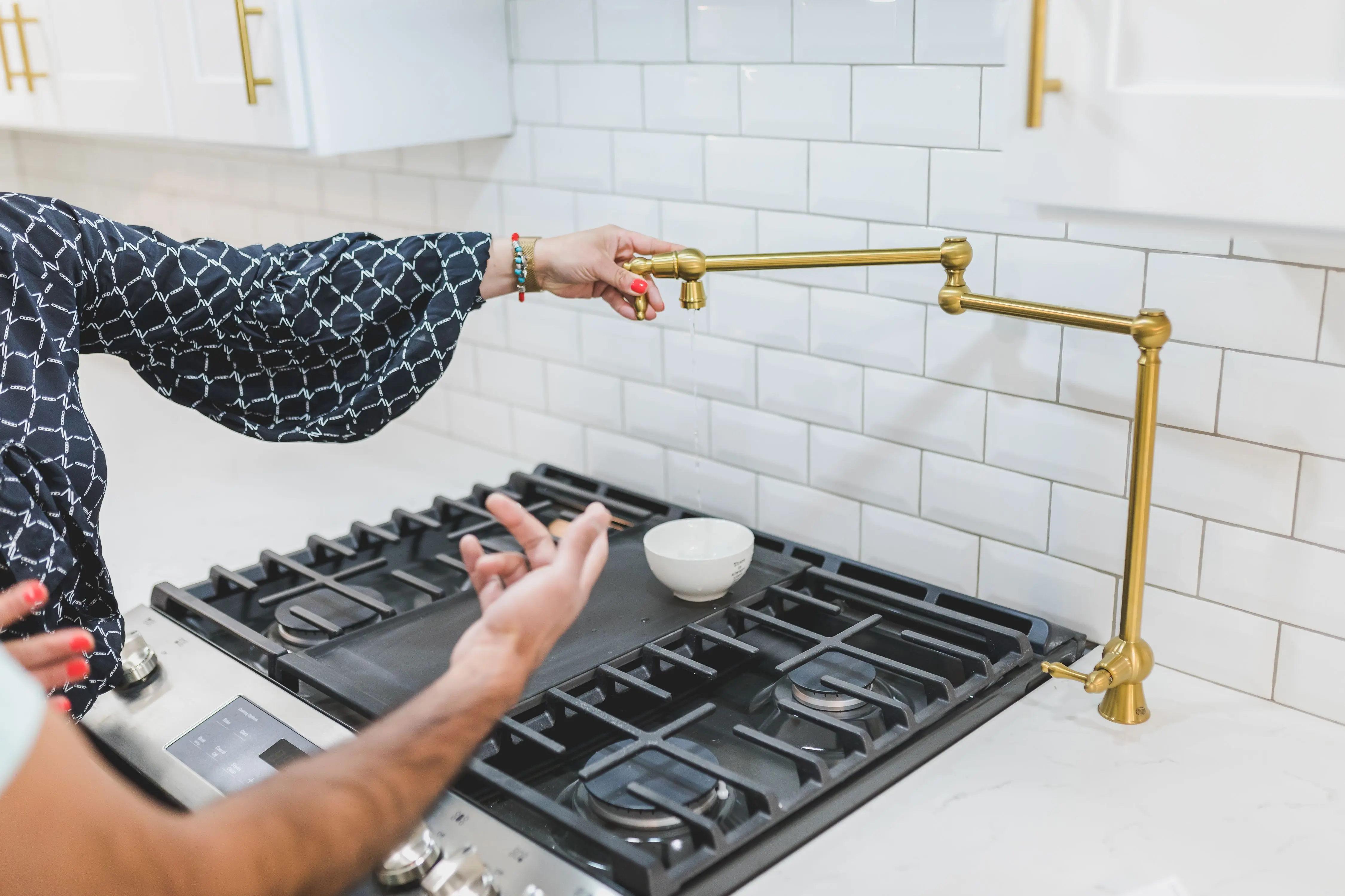 white kitchen backsplash A stylish kitchen featuring a brass pot filler faucet and gas stove. Perfect for culinary enthusiasts and home design inspiration.