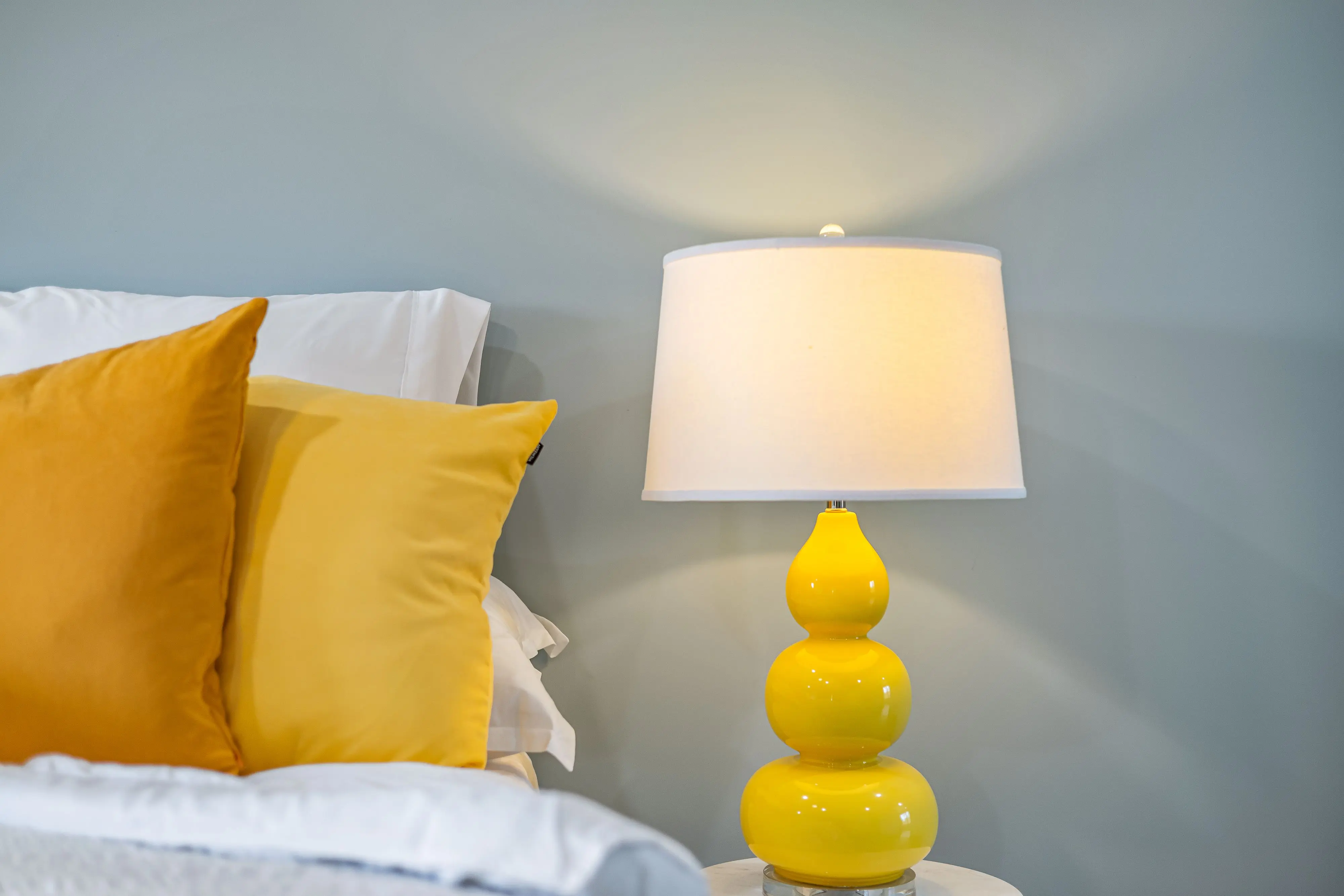 yellow throw pillows Cozy bedroom interior featuring yellow accents and a chic bedside lamp for a warm ambiance.