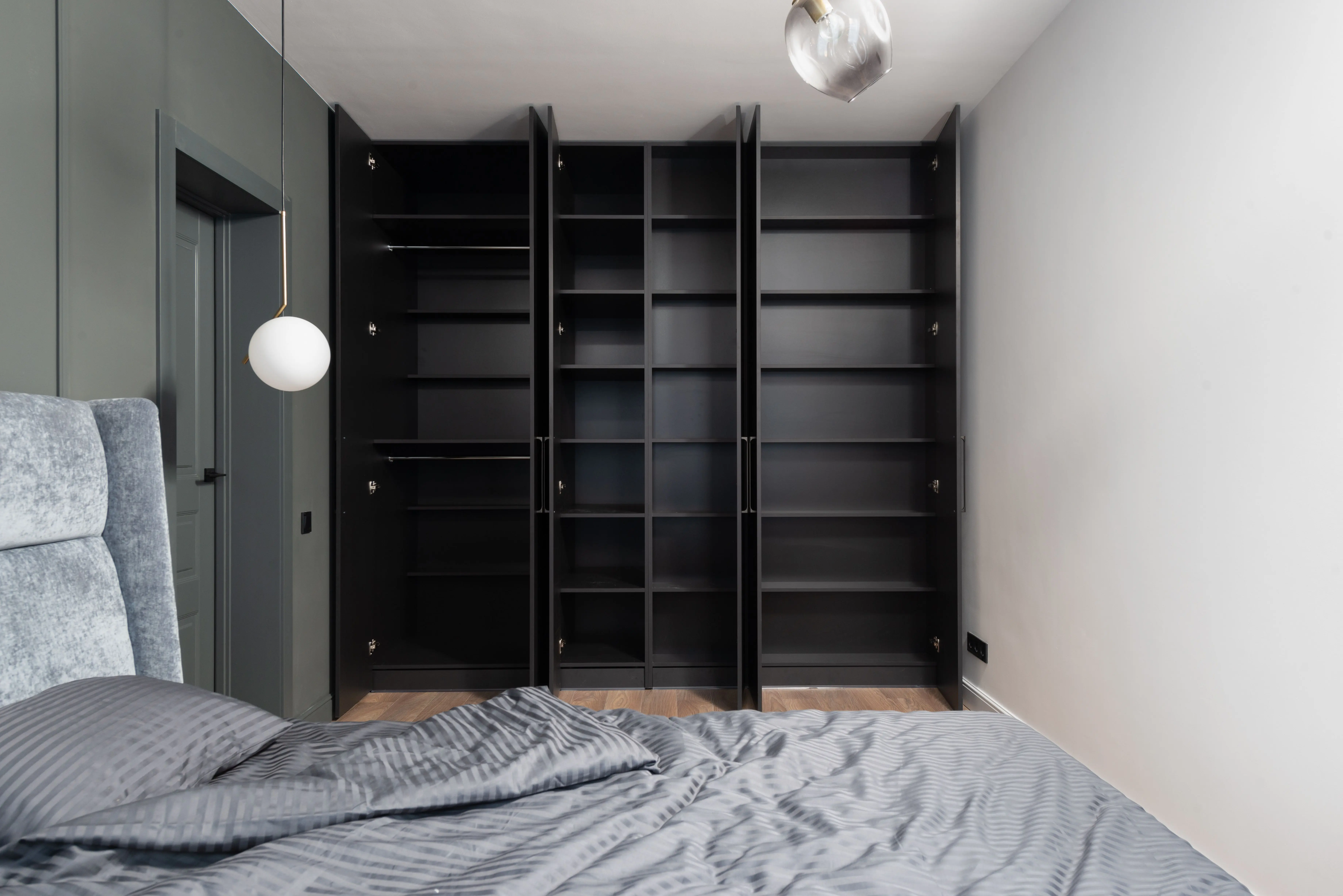solid wood armoire wardrobe Contemporary bedroom interior with open black wardrobes and minimalist design elements.
