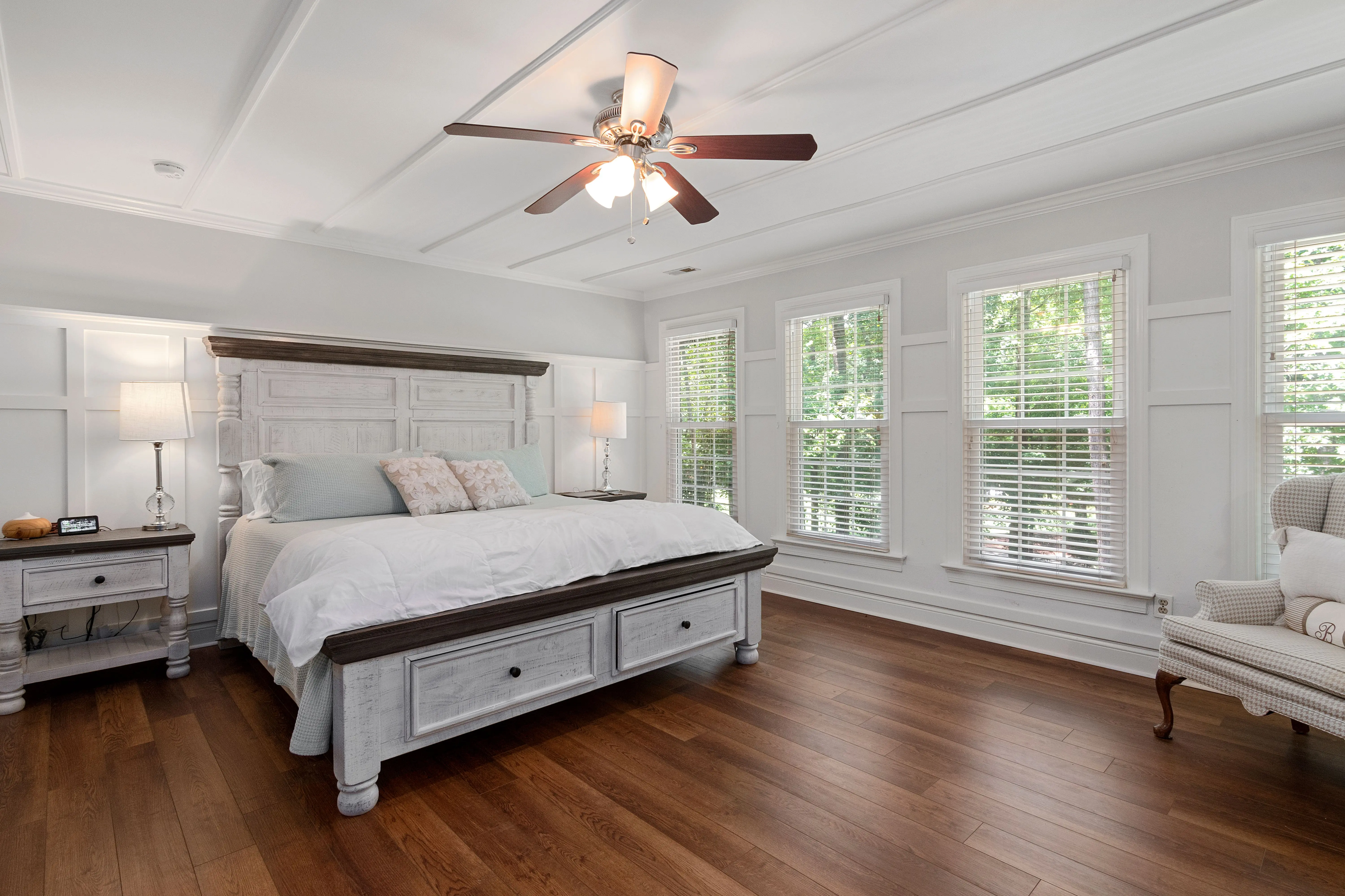 california king bed frame with storage Bright and spacious bedroom with a wooden floor and white furniture, perfect for relaxation.