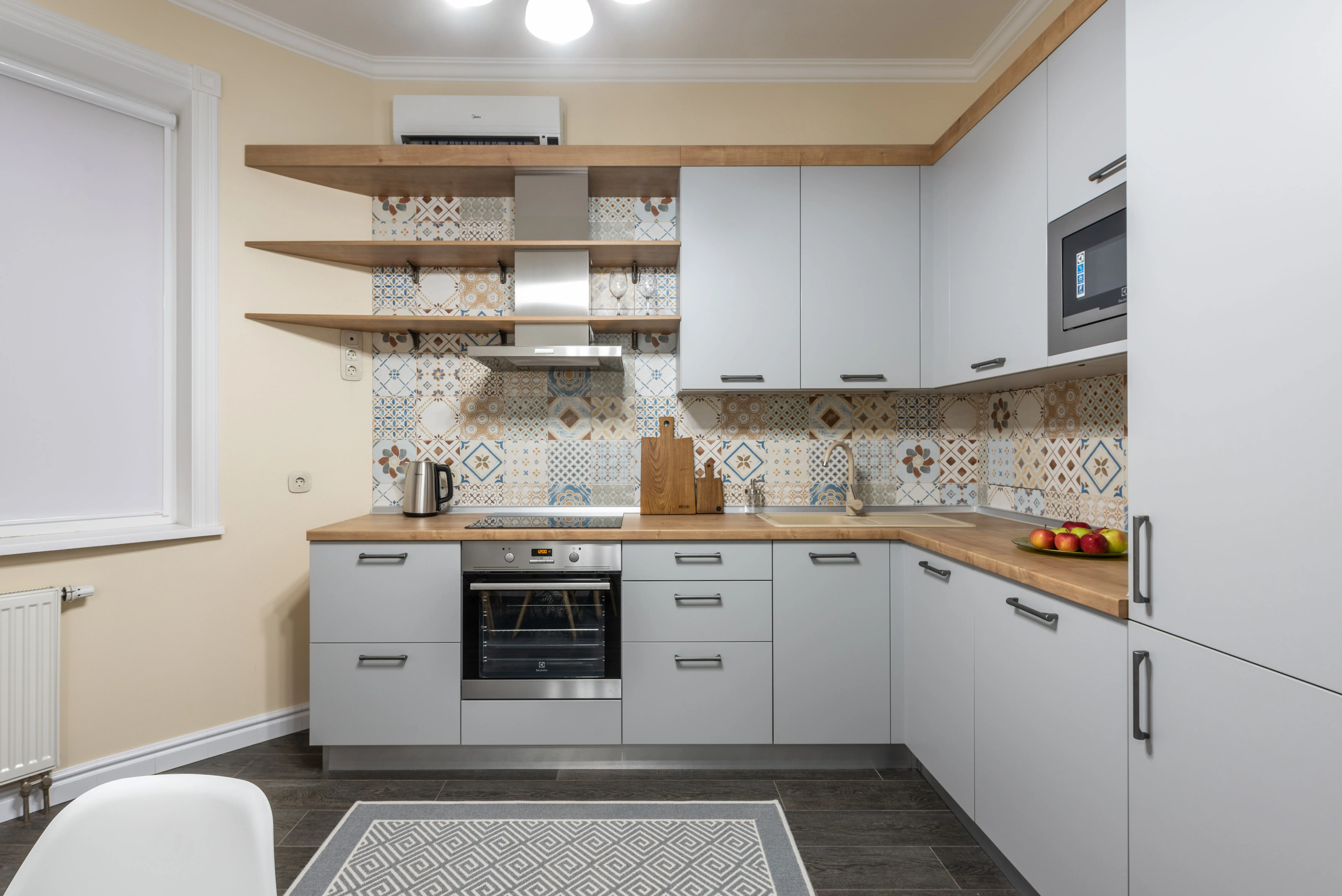 wood wall shelf Modern kitchen with cabinets and electric stove with oven under hood illuminated by shiny lamp in house