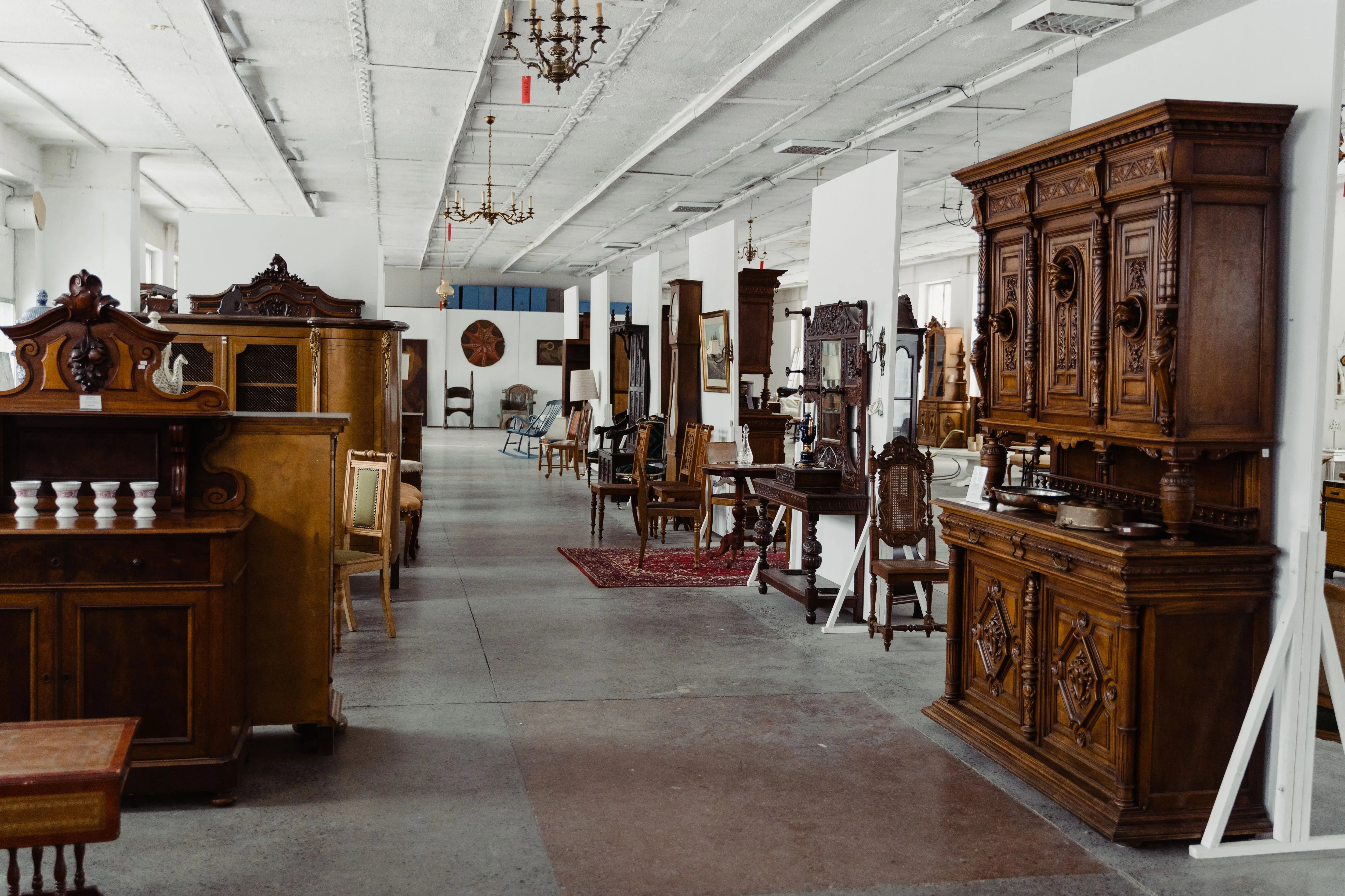 solid wood armoire wardrobe A spacious showroom filled with various antique wooden furniture pieces on display.