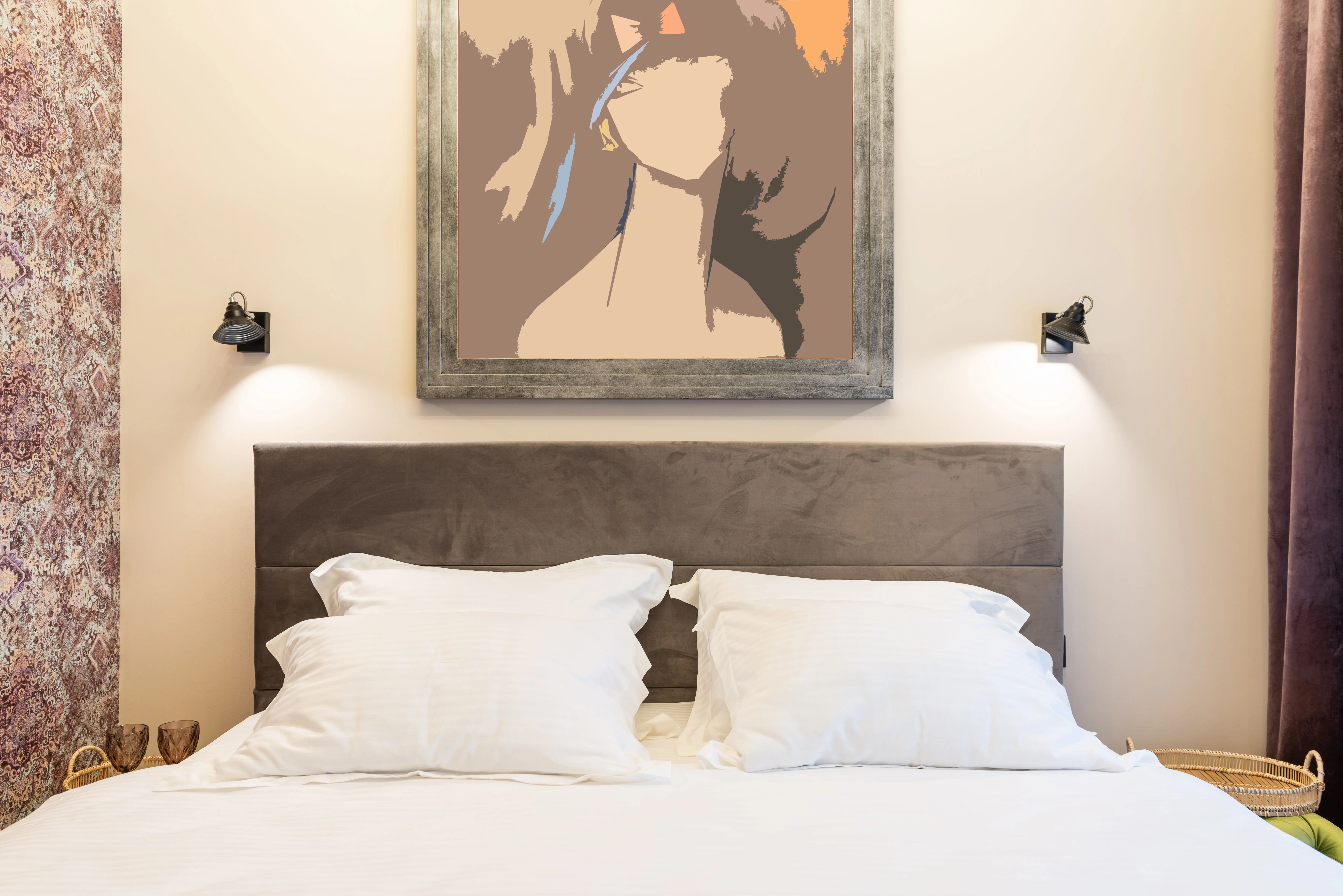 bedroom art Soft pillows on bed against artwork on wall with shiny lamps and ornament in house