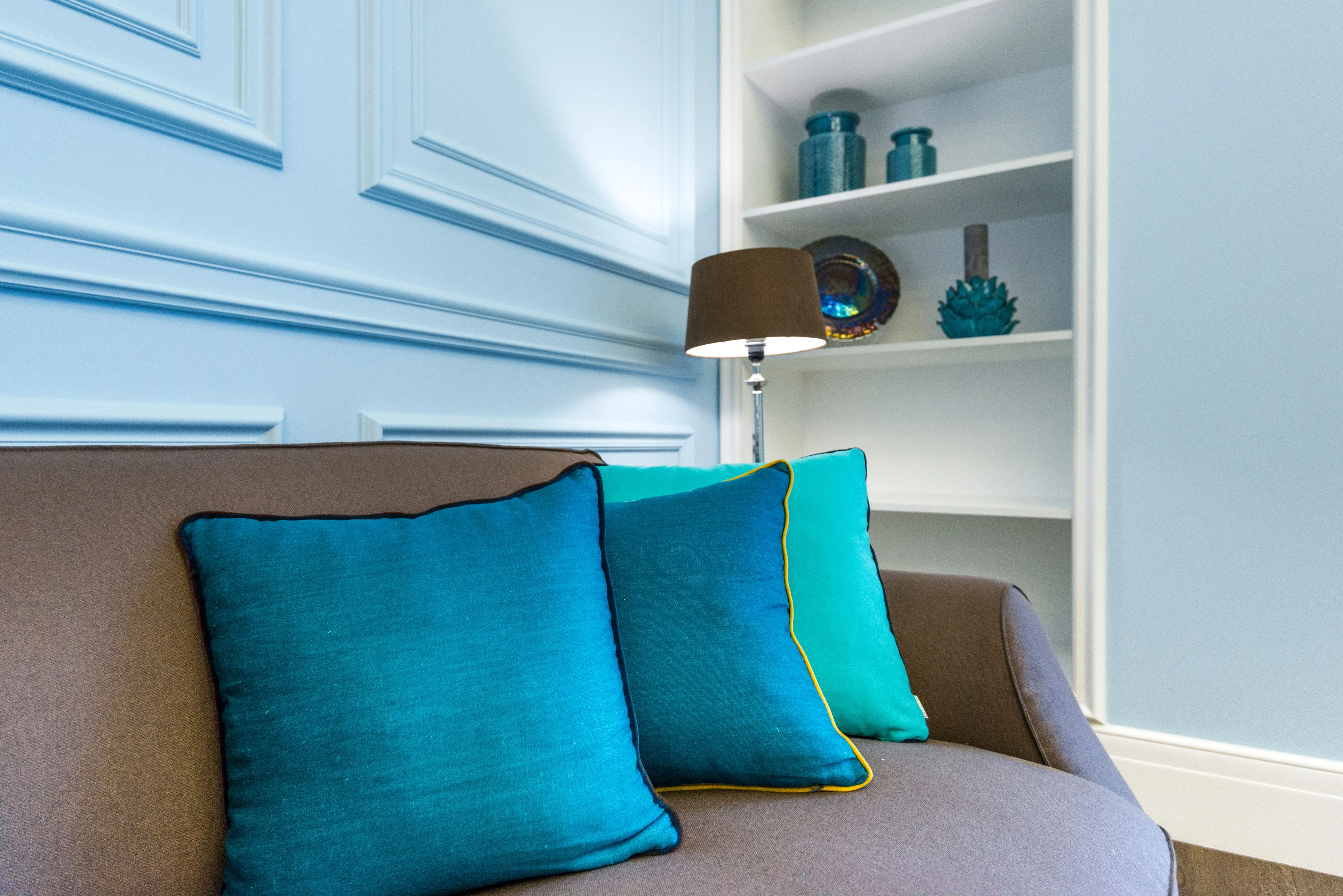 blue decorative pillows A stylish interior design showcasing a couch with vibrant turquoise accent pillows.