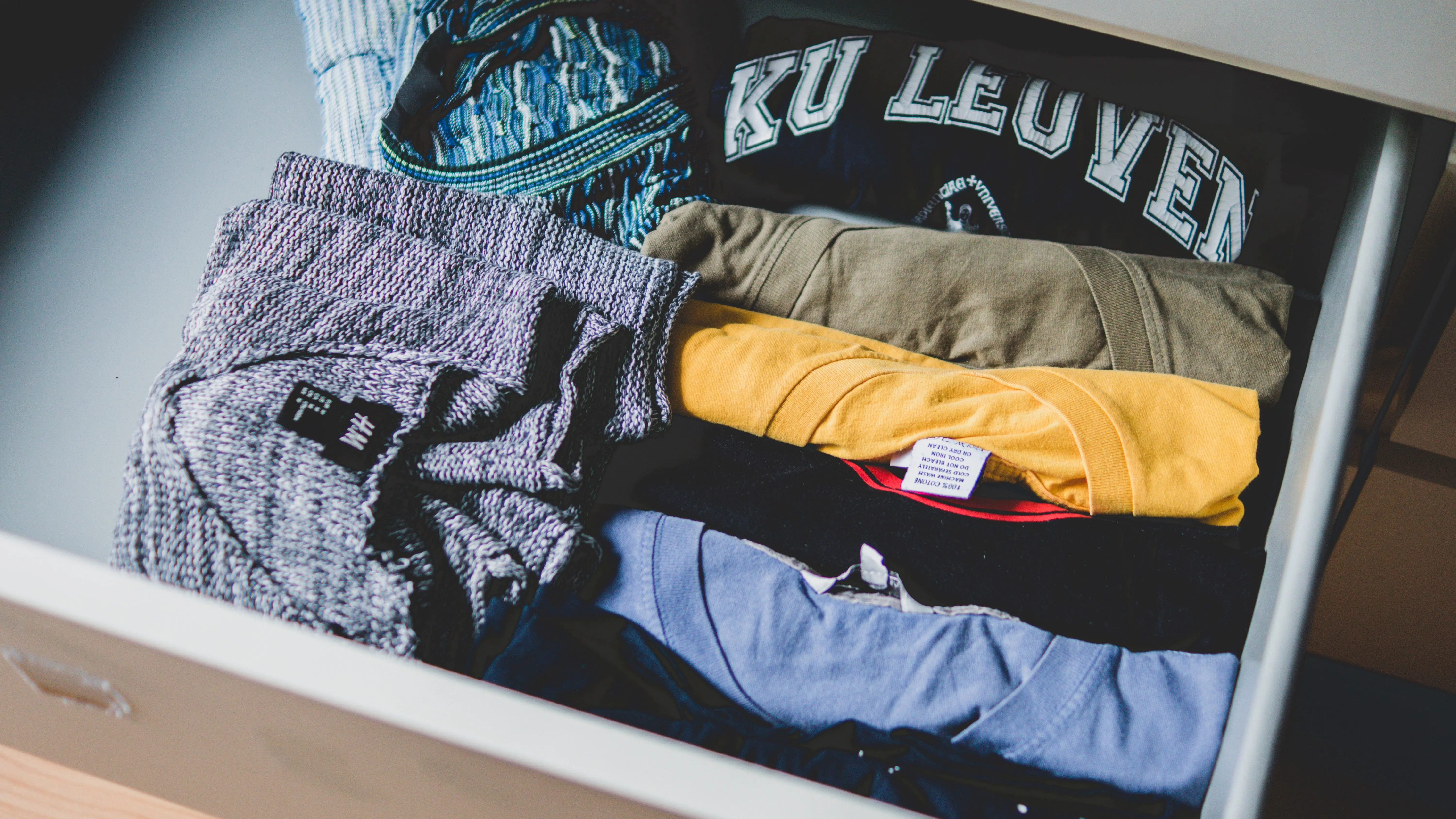 wardrobe closet with drawers A neat arrangement of clothes and T-shirts in a drawer, showcasing casual wear.