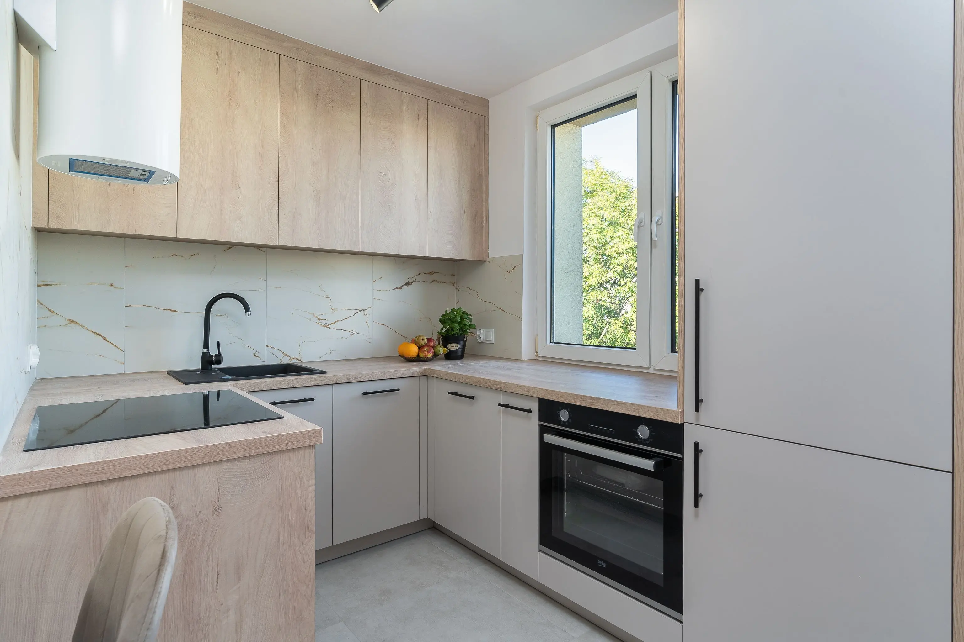 unique cabinet hardware Bright minimalist kitchen with light wood cabinetry and modern appliances.