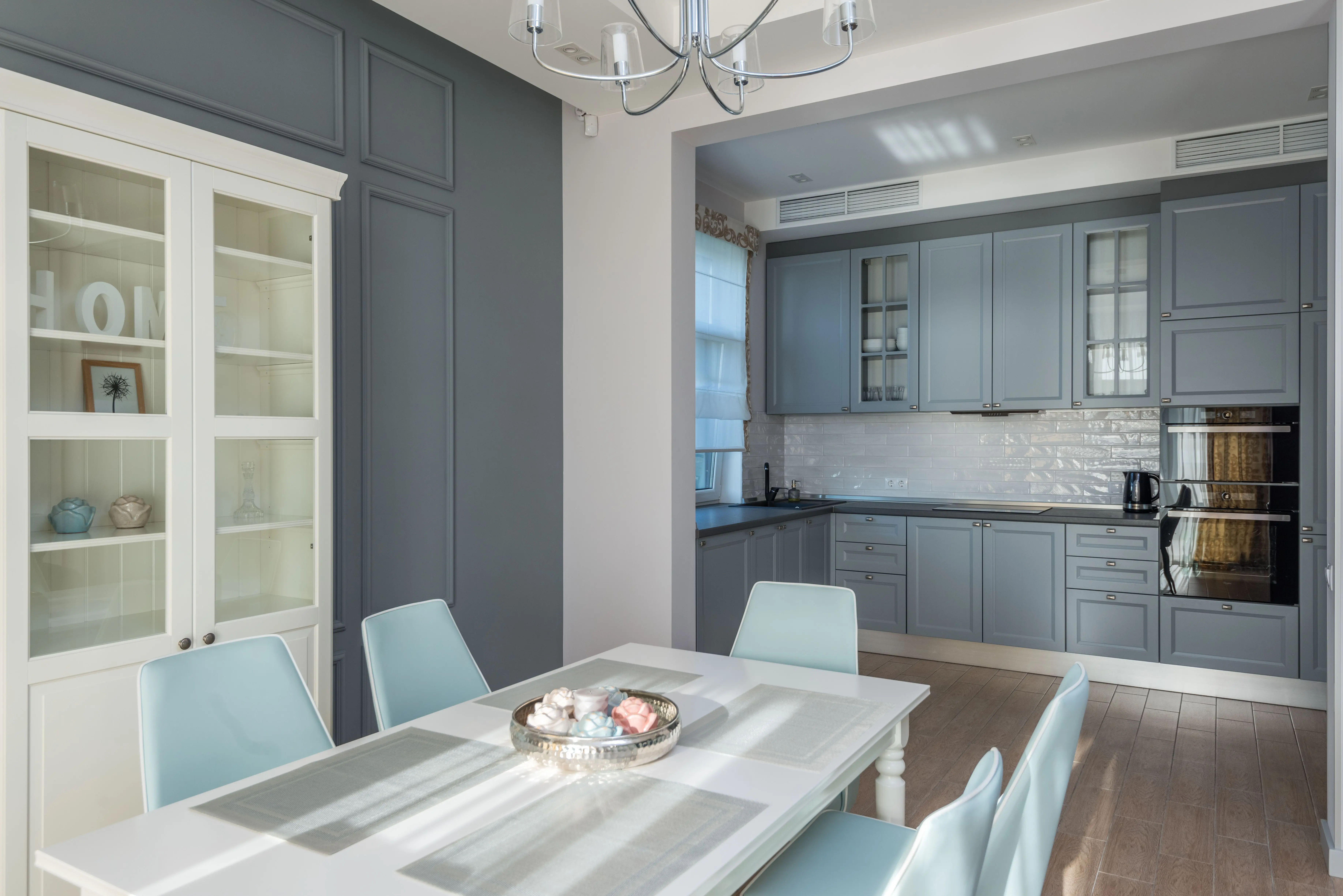 dark grey kitchen cabinets Chic dining room with pastel chairs and grey kitchen cabinets. Perfect for modern interior design inspiration.