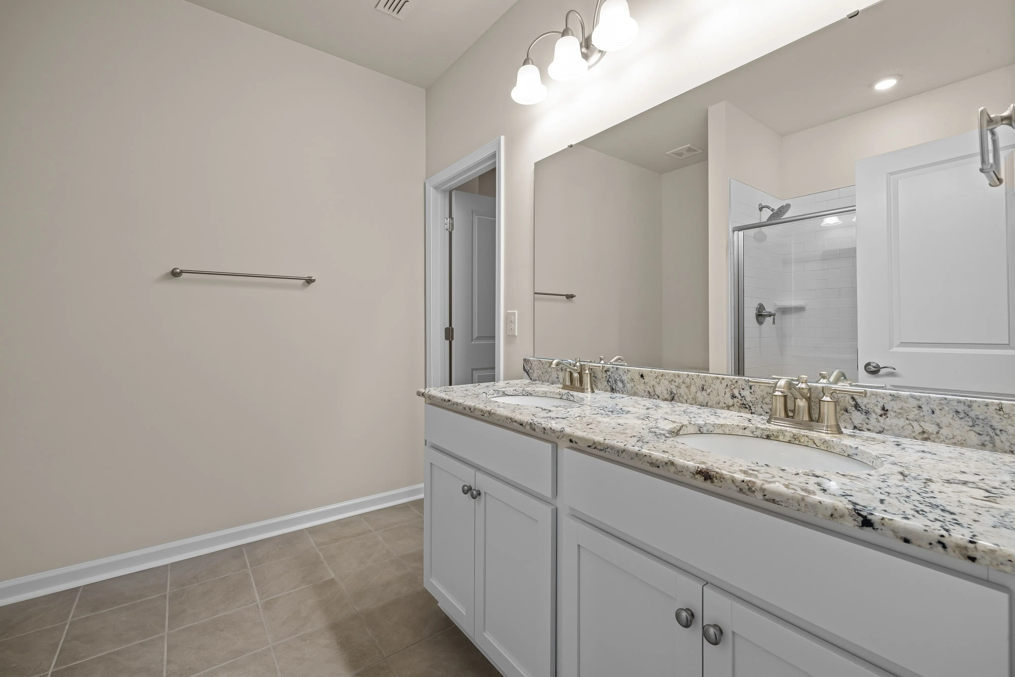 double bathroom vanities Sleek contemporary bathroom featuring double sinks, granite countertops, and white cabinetry.