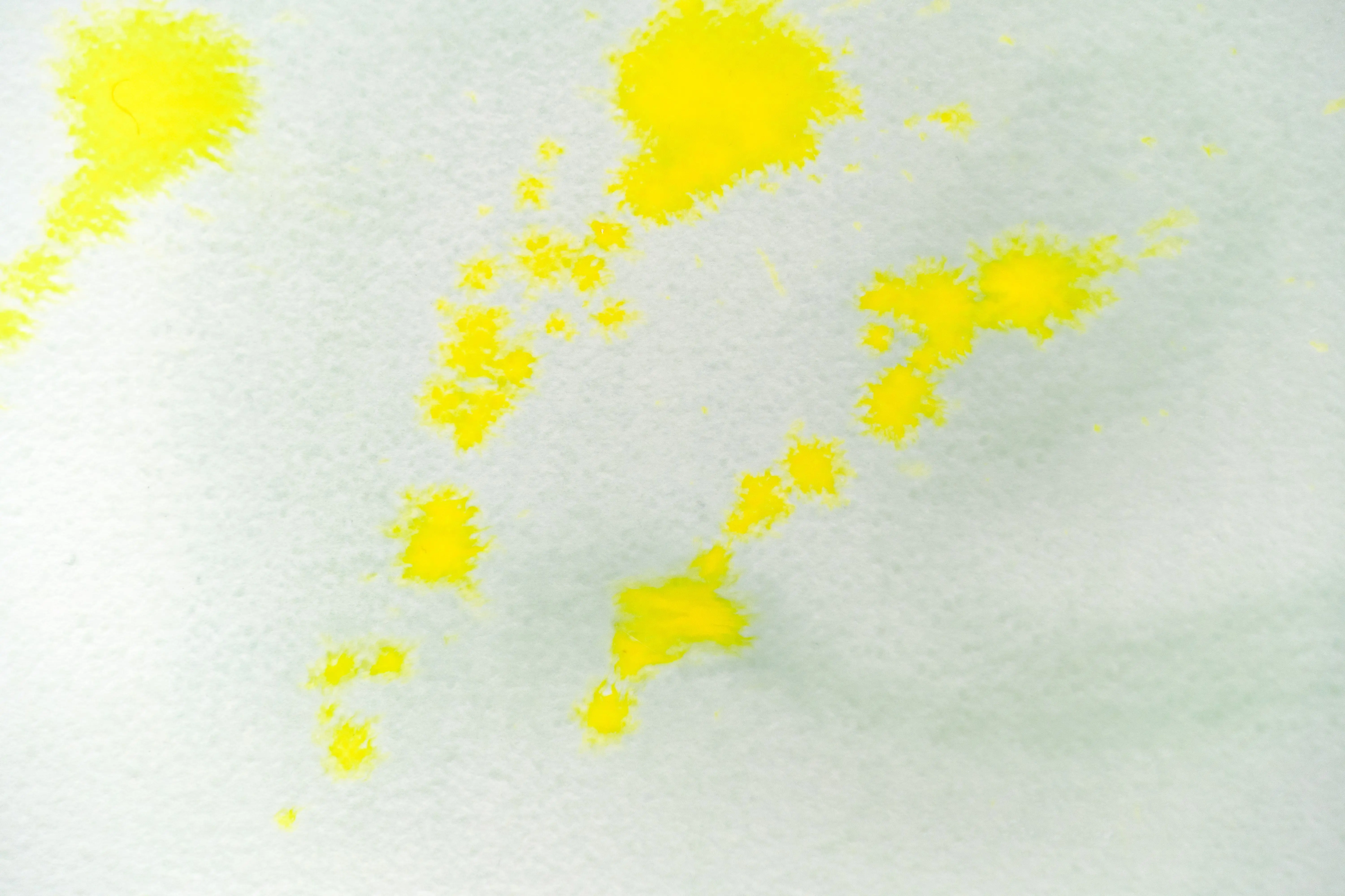 a water based paint Abstract yellow watercolor splashes on textured canvas background. Ideal for art and design projects.