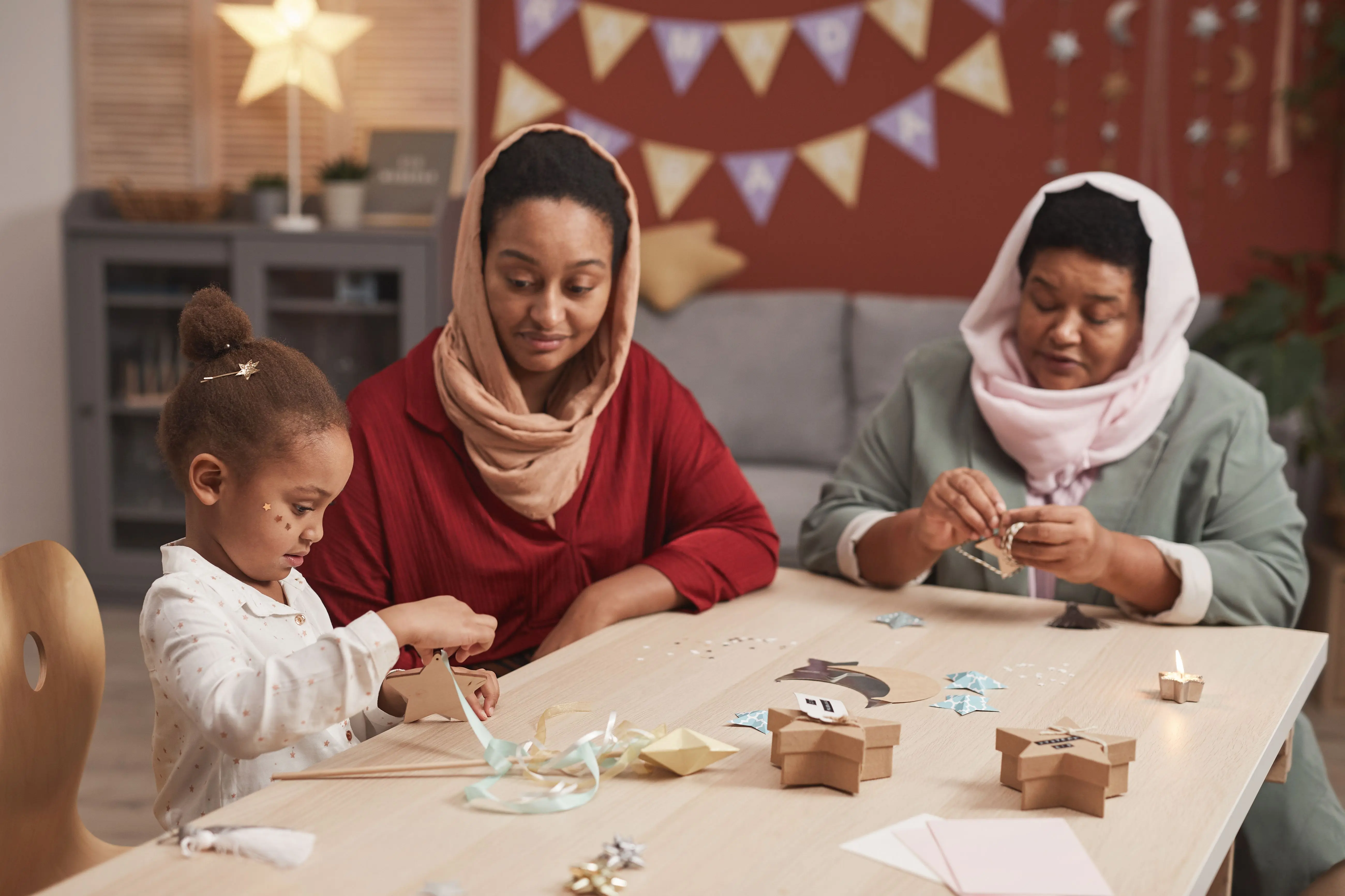 christmas craft kits Family crafting session with three generations creating paper decorations indoors.