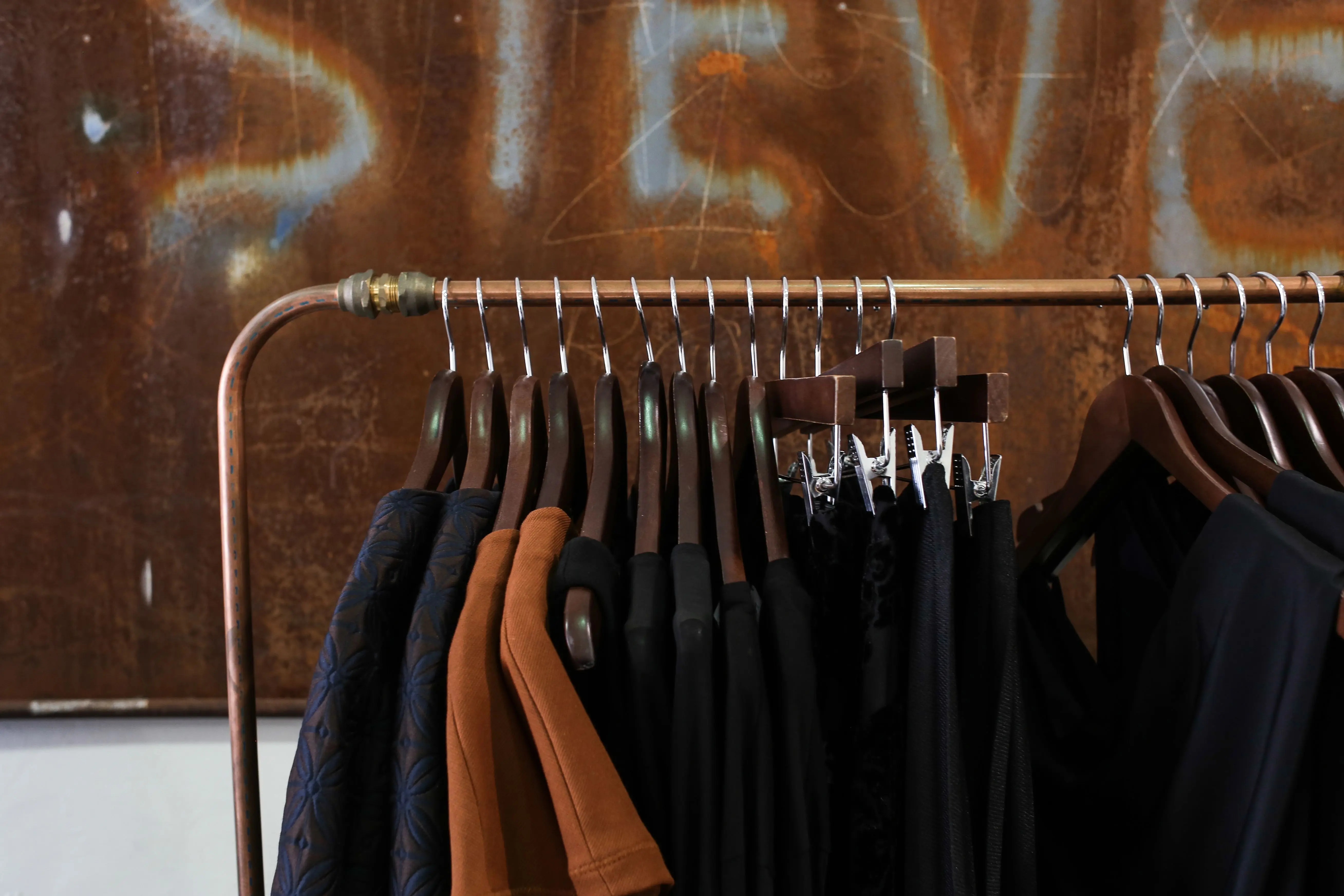 closet rod height Modern clothing rack in a boutique with diverse garments and wooden hangers