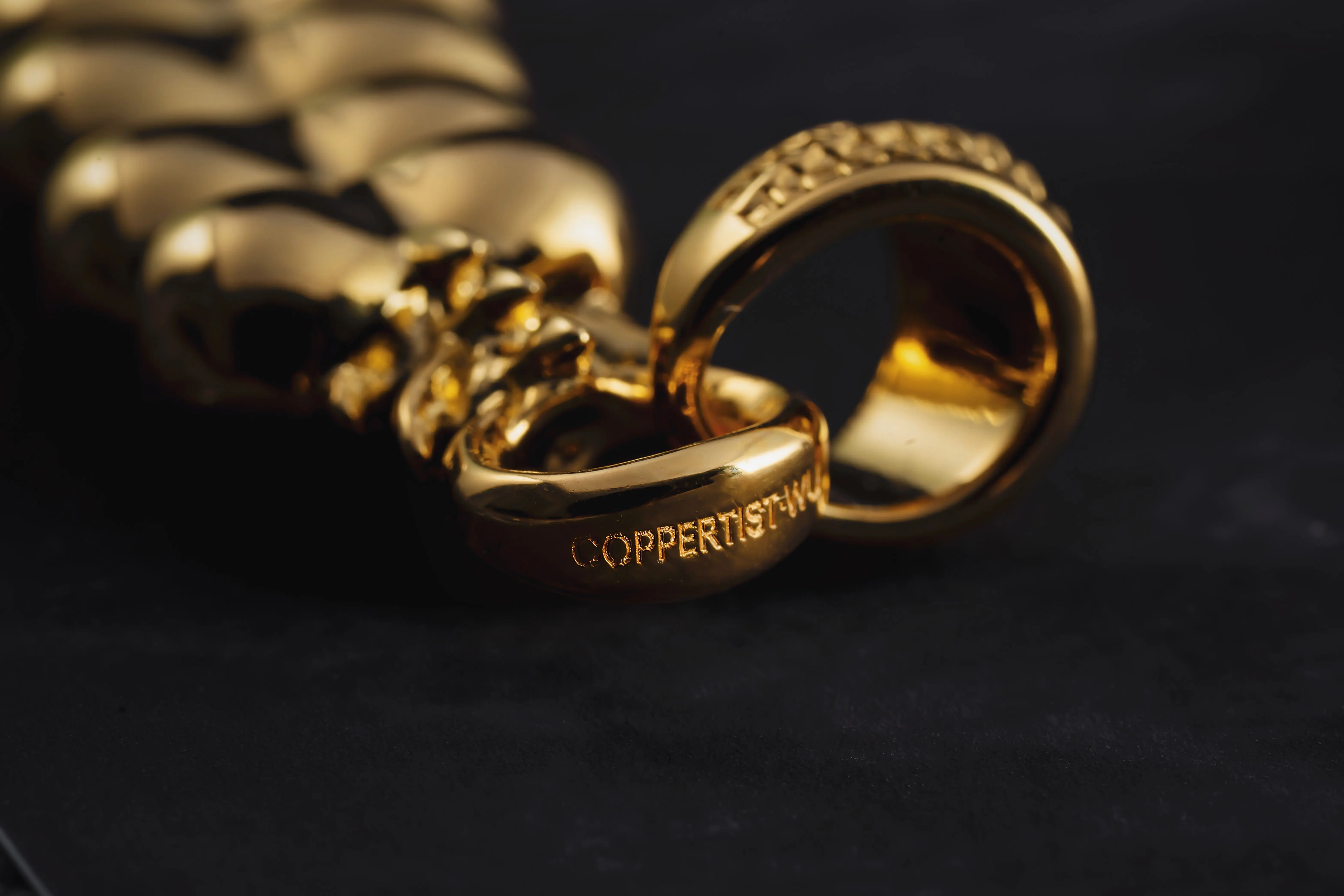 gold drawer pulls Close-up of gold rings with intricate design on a black background.