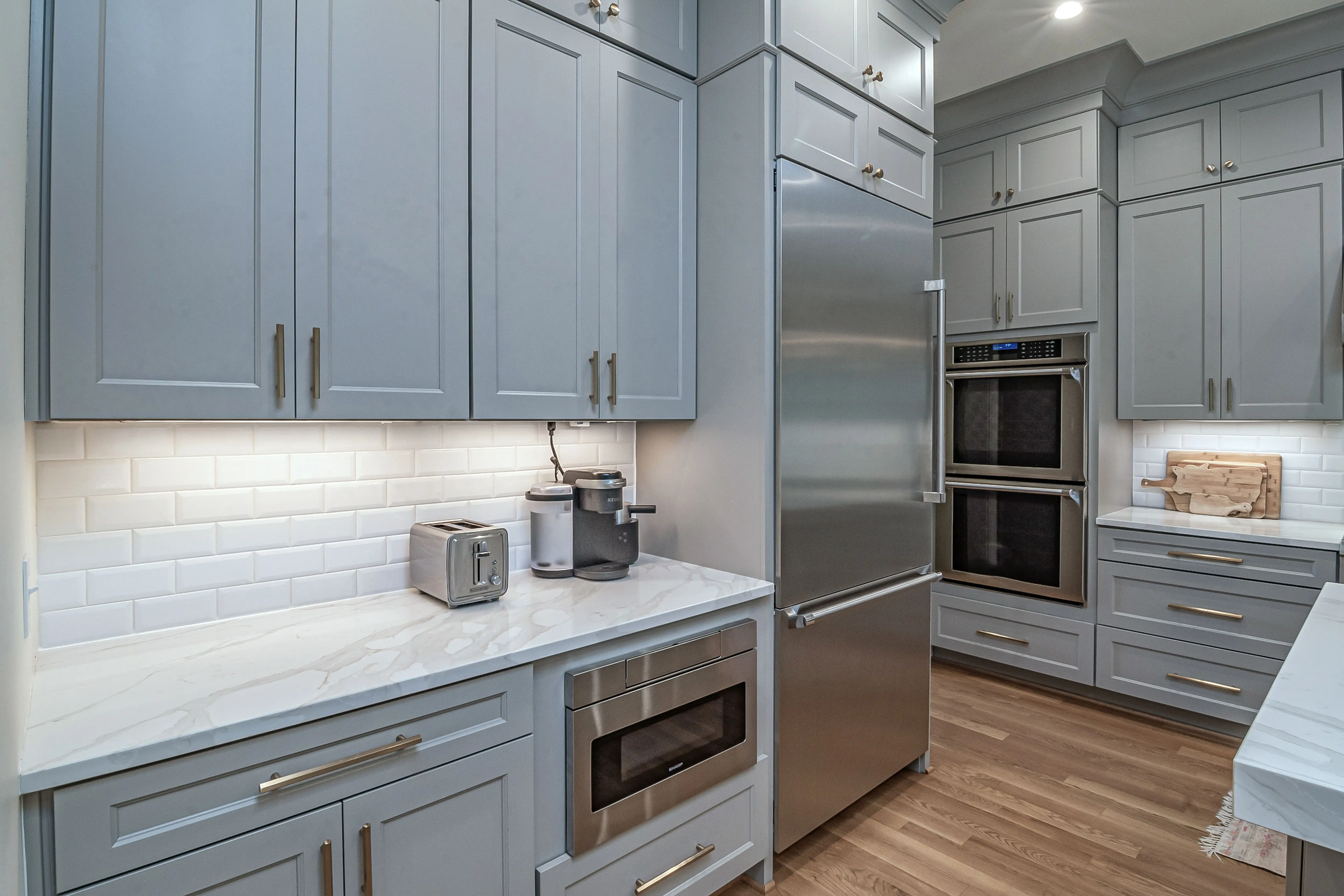 dark grey kitchen cabinets Sleek modern kitchen featuring stainless steel appliances and light grey cabinets.