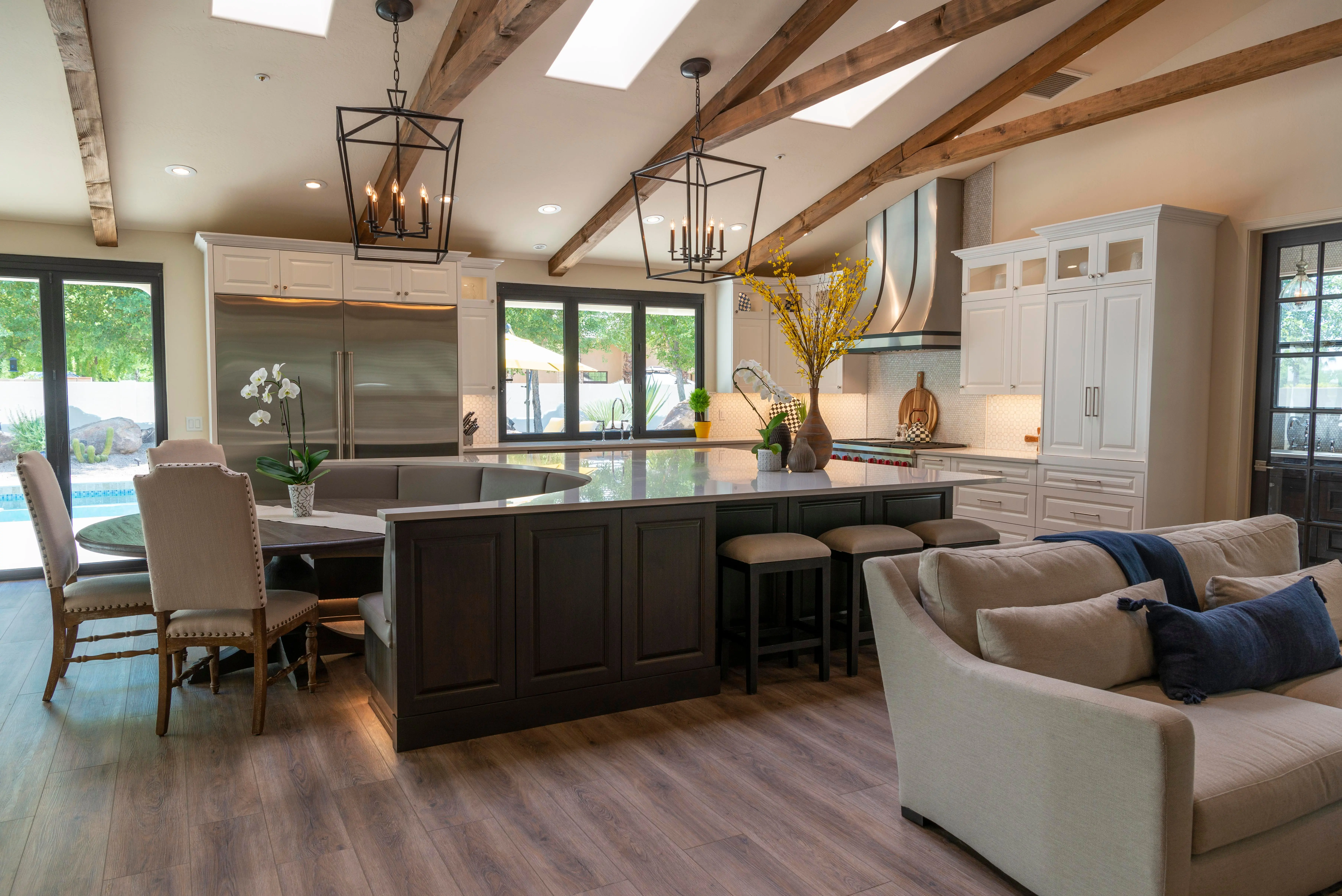 dark grey kitchen cabinets Luxurious open concept kitchen featuring sleek cabinetry, large island, and stylish lighting.